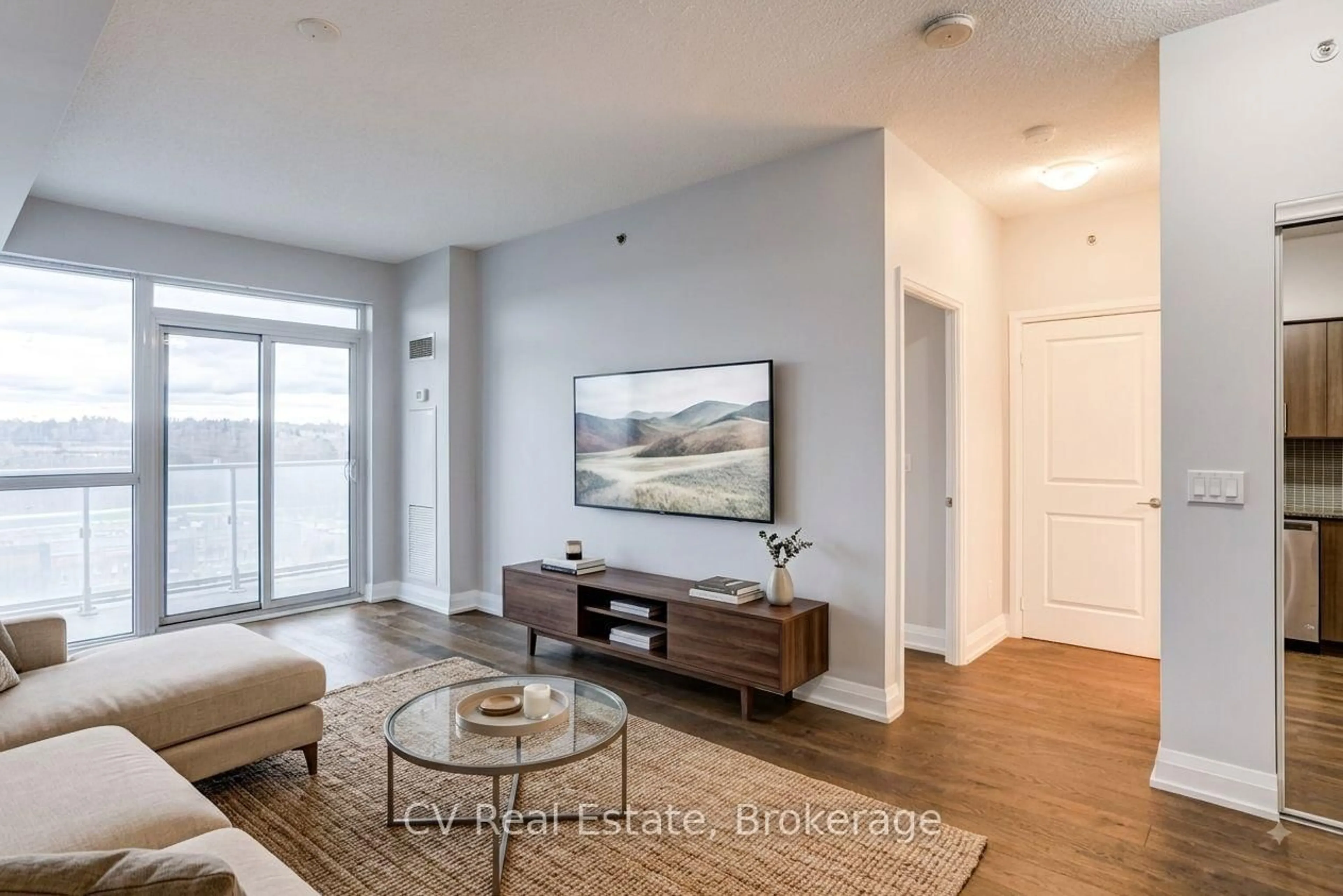 Living room with furniture, wood/laminate floor for 65 Speers Rd #602, Oakville Ontario L6K 0J1
