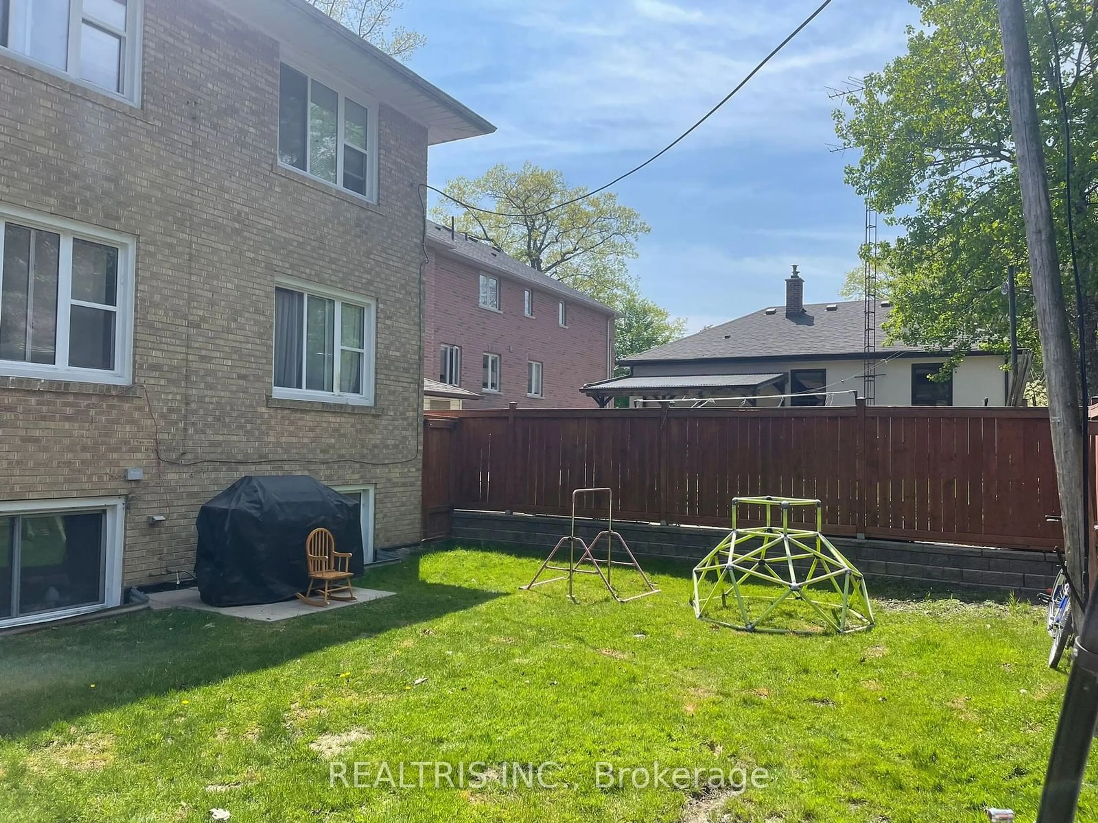 Frontside or backside of a home, the fenced backyard for 18 Muskoka Ave, Toronto Ontario M8W 1H3