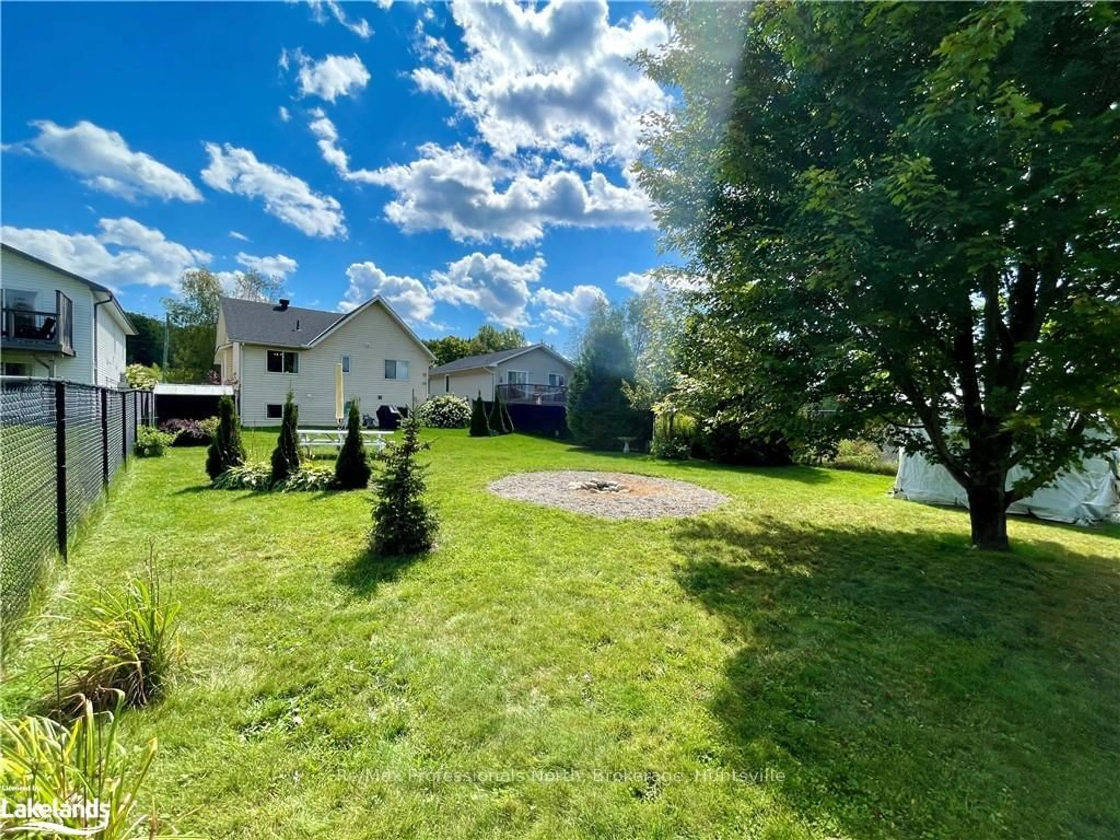 Frontside or backside of a home, the fenced backyard for 21 CAIRNS Cres, Huntsville Ontario P1H 1Y3