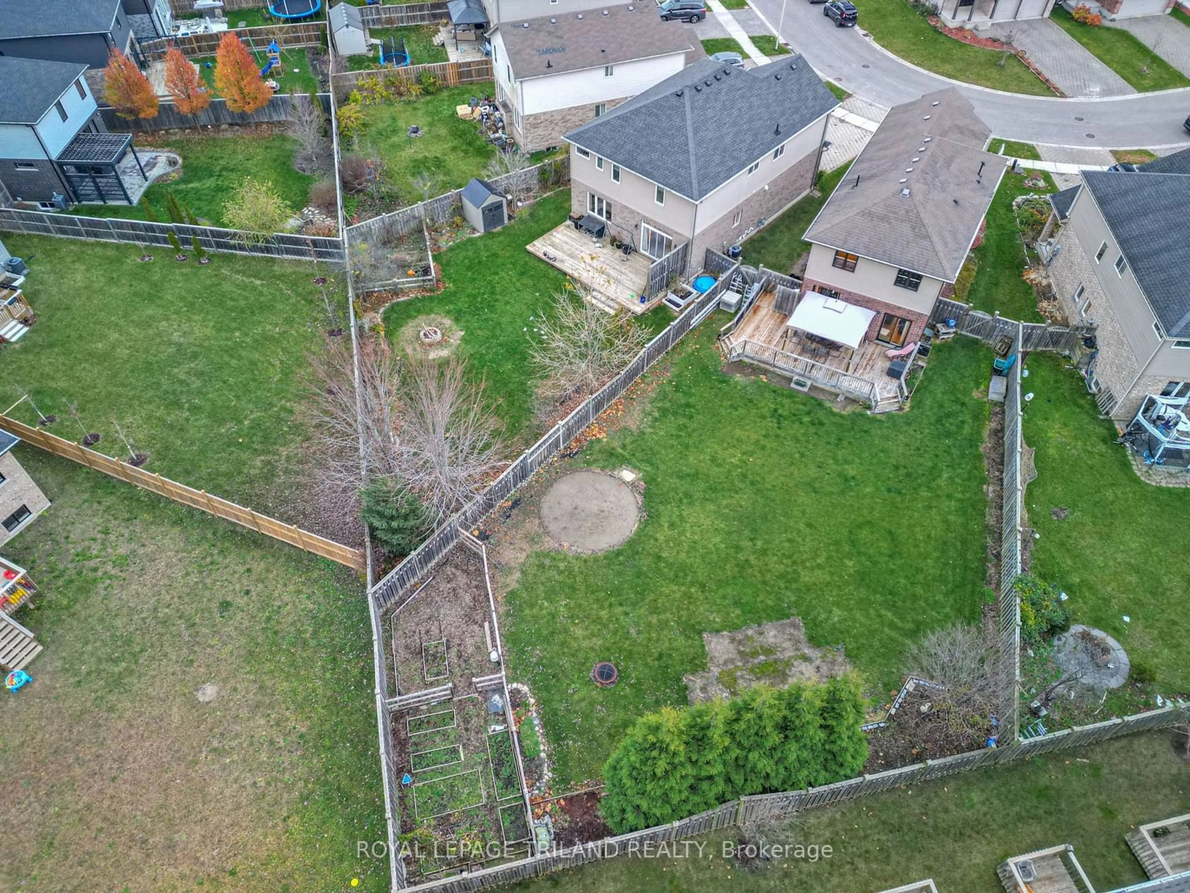 Frontside or backside of a home, the fenced backyard for 711 Springwood Cres, London Ontario N6G 0H8