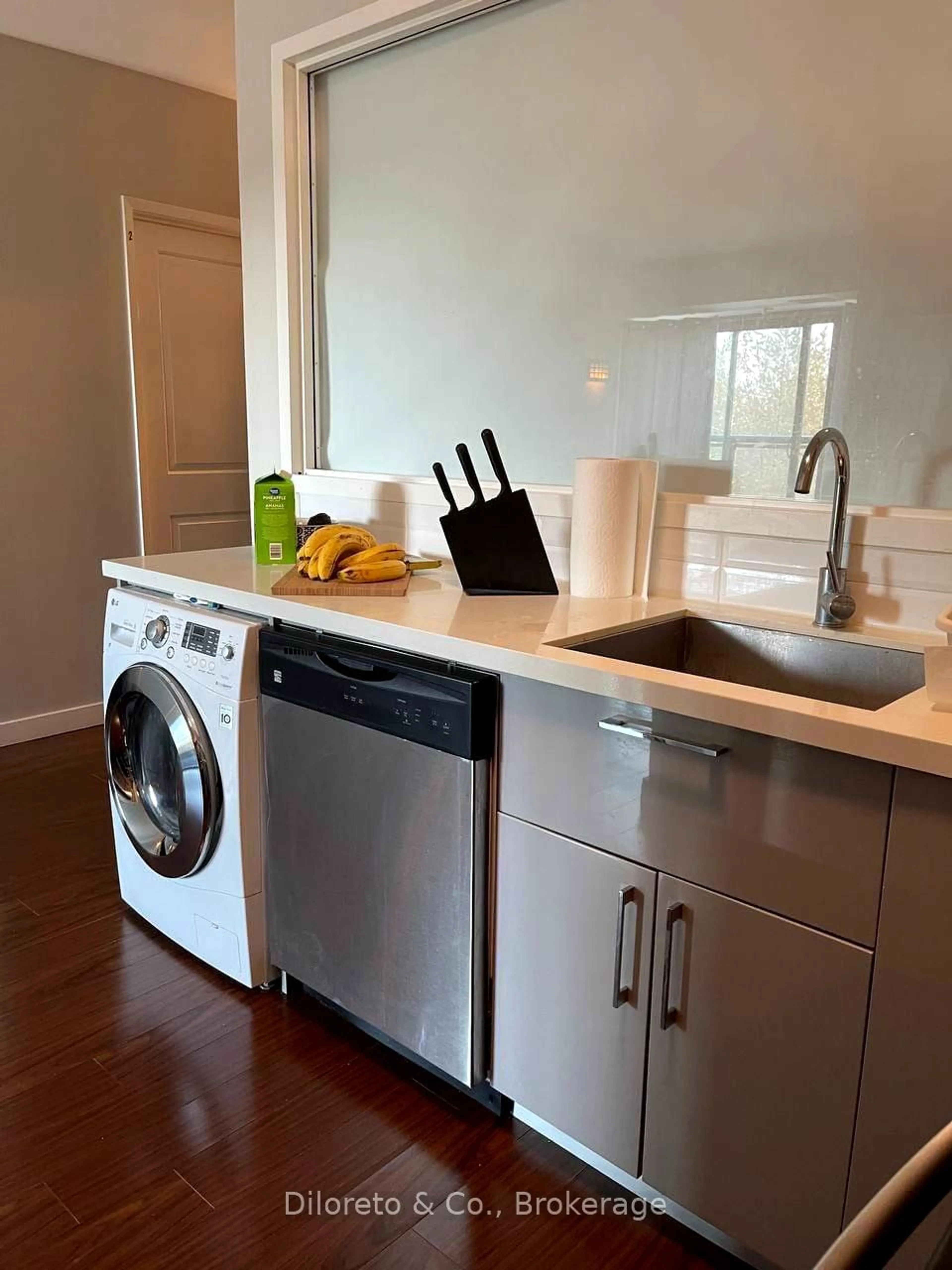 Kitchen with laundary machines, wood/laminate floor for 1291 Gordon St #218, Guelph Ontario N1L 0M5