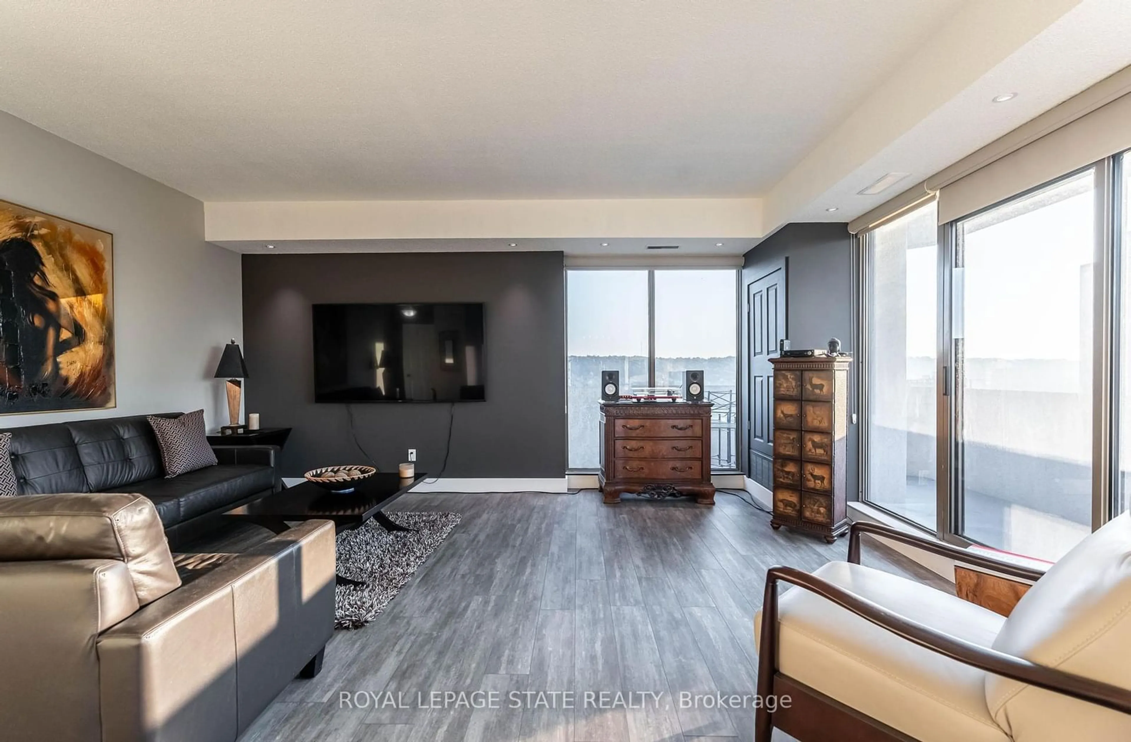 Living room with furniture, wood/laminate floor for 67 Caroline St #1703, Hamilton Ontario L8P 3K6