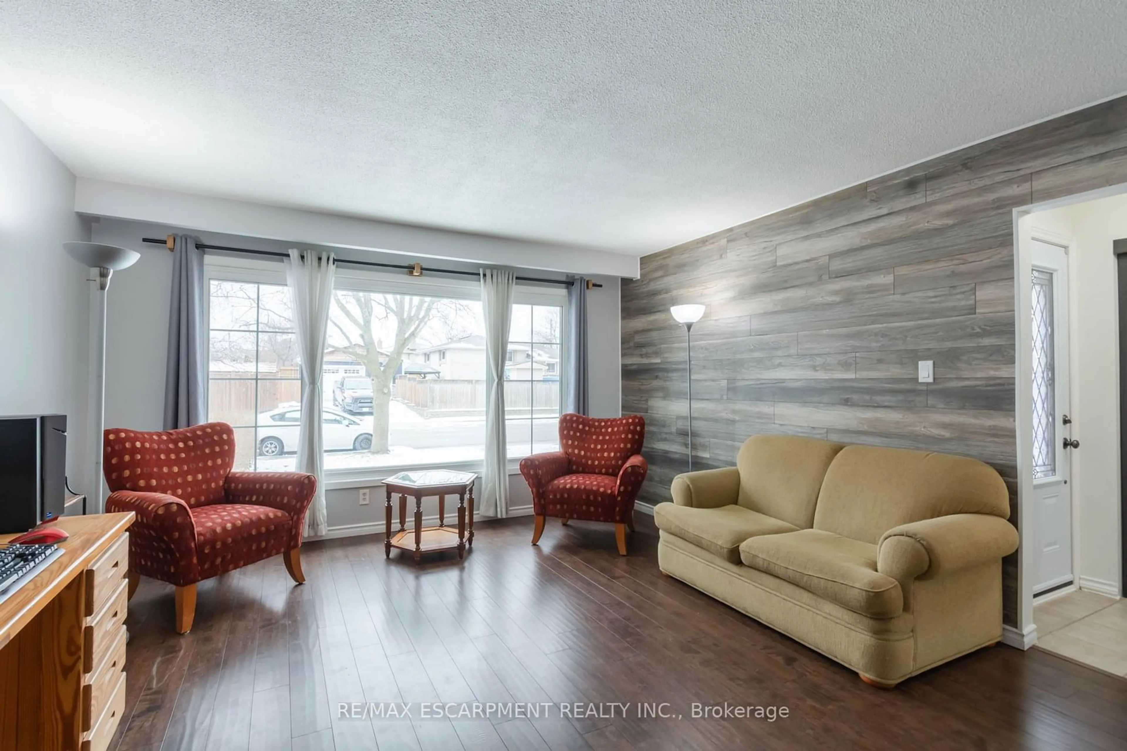 Living room with furniture, wood/laminate floor for 117 Anna Capri Dr, Hamilton Ontario L8W 1M7