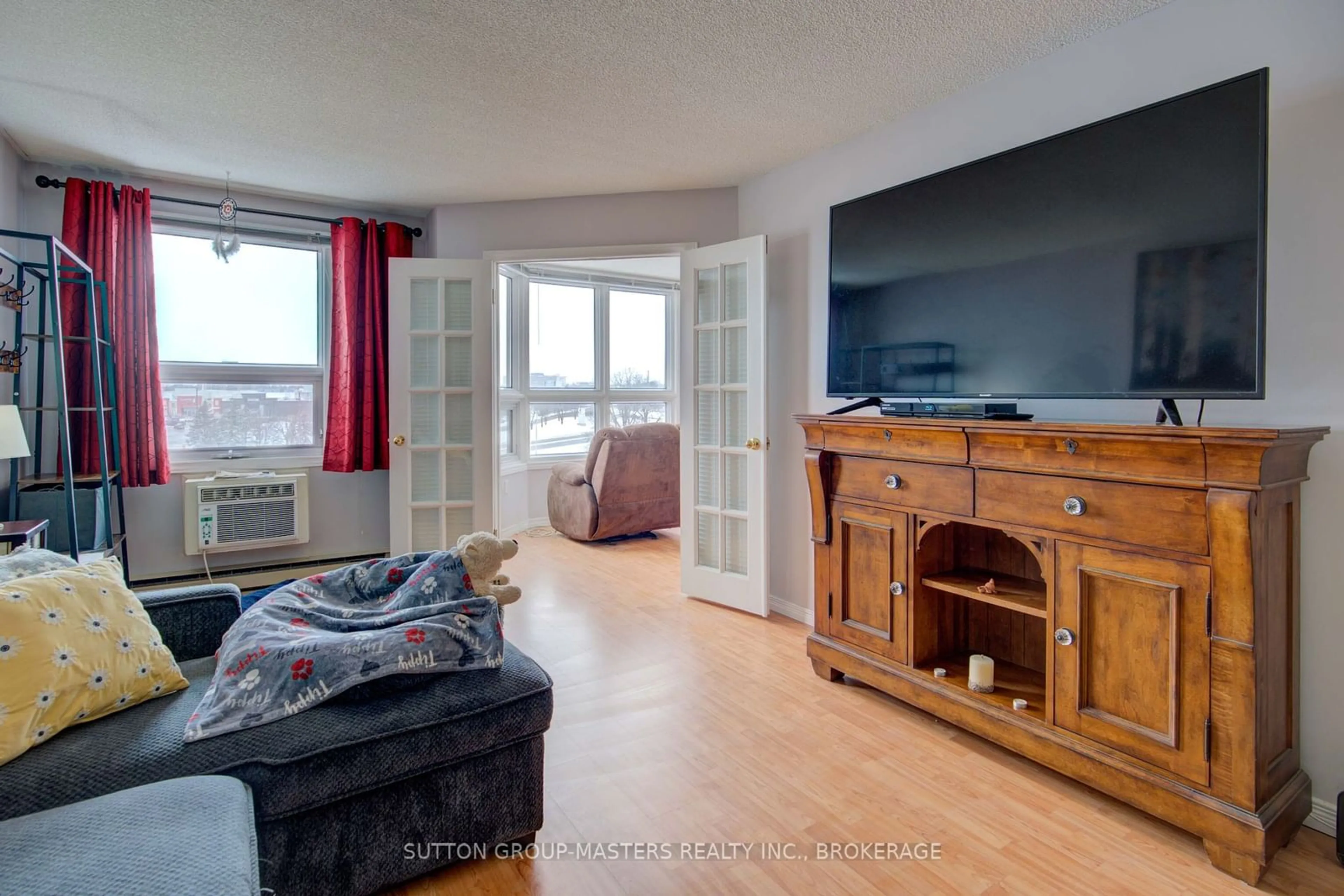 Living room with furniture, wood/laminate floor for 675 Davis Dr #607, Kingston Ontario K7M 8L5