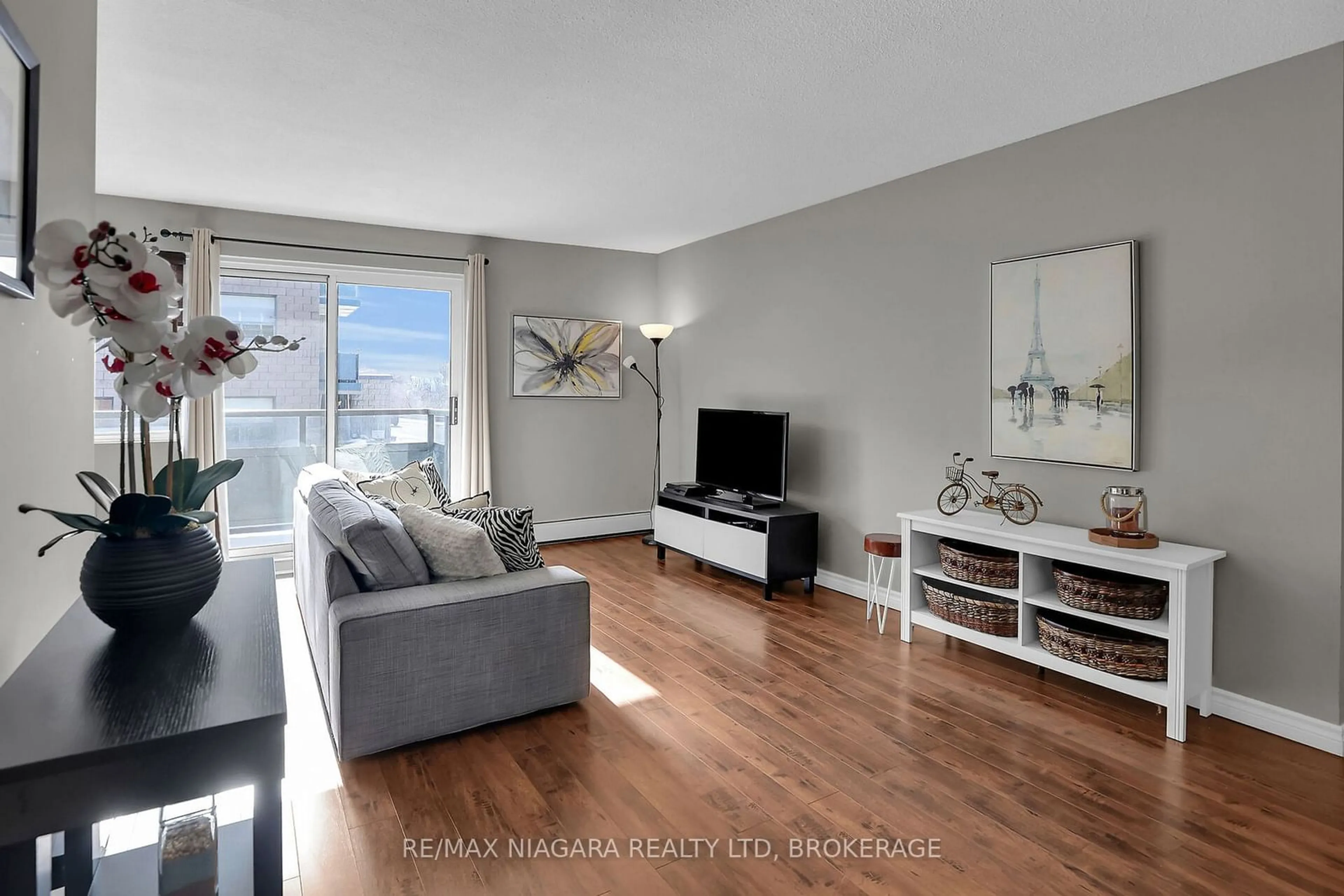 Living room with furniture, wood/laminate floor for 242 Oakdale Ave #202, St. Catharines Ontario L2P 3K5