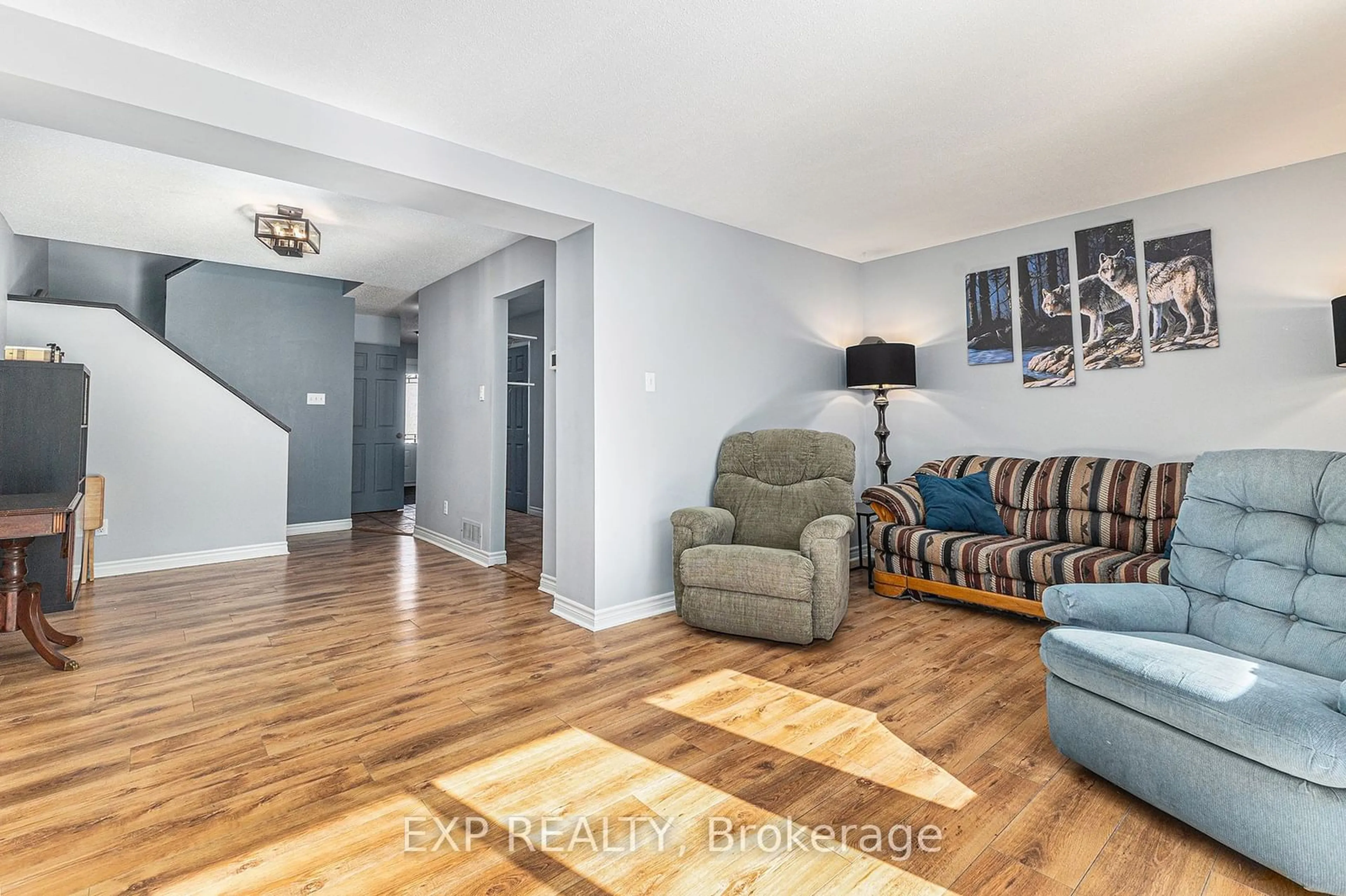 Living room with furniture, wood/laminate floor for 84 Woodford Way, Barrhaven Ontario K2J 4B5