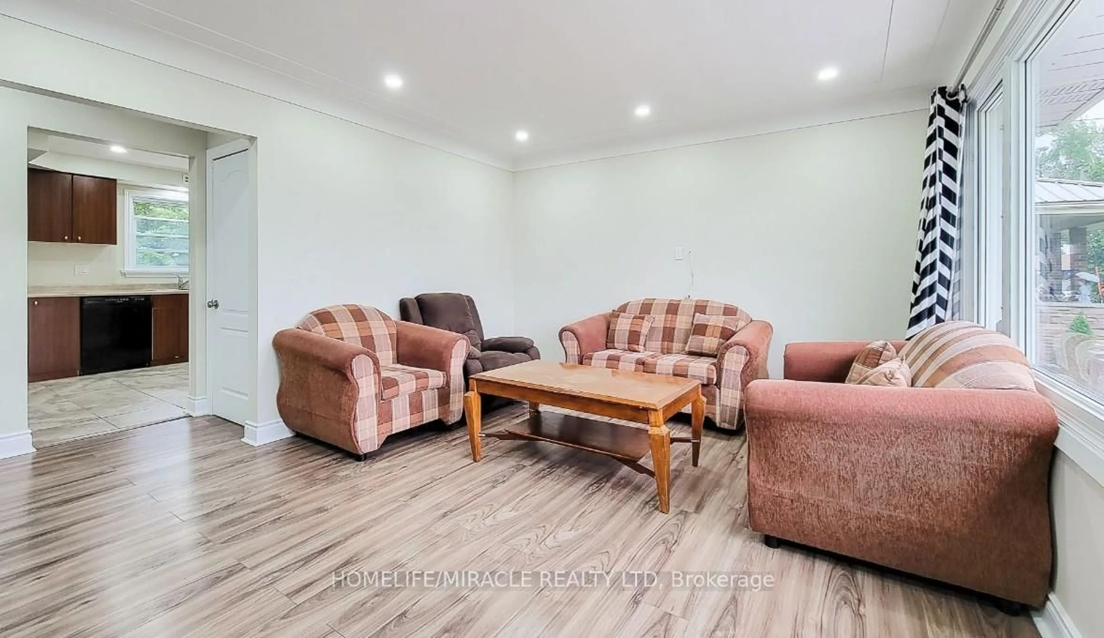 Living room with furniture, wood/laminate floor for 7150 Douglas Cres, Niagara Falls Ontario L2G 3C4