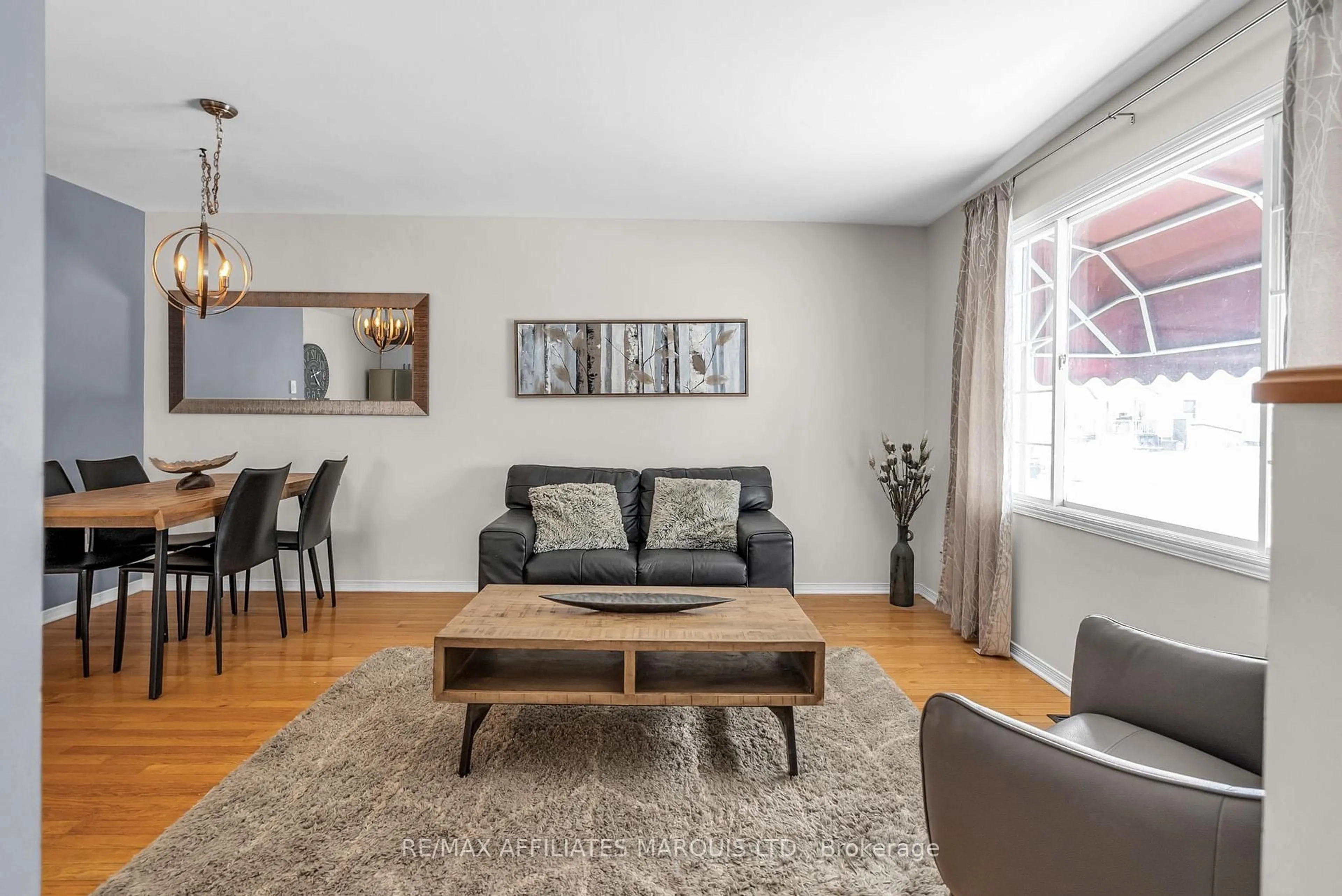 Living room with furniture, wood/laminate floor for 407 Carleton St, Cornwall Ontario K6H 4X9