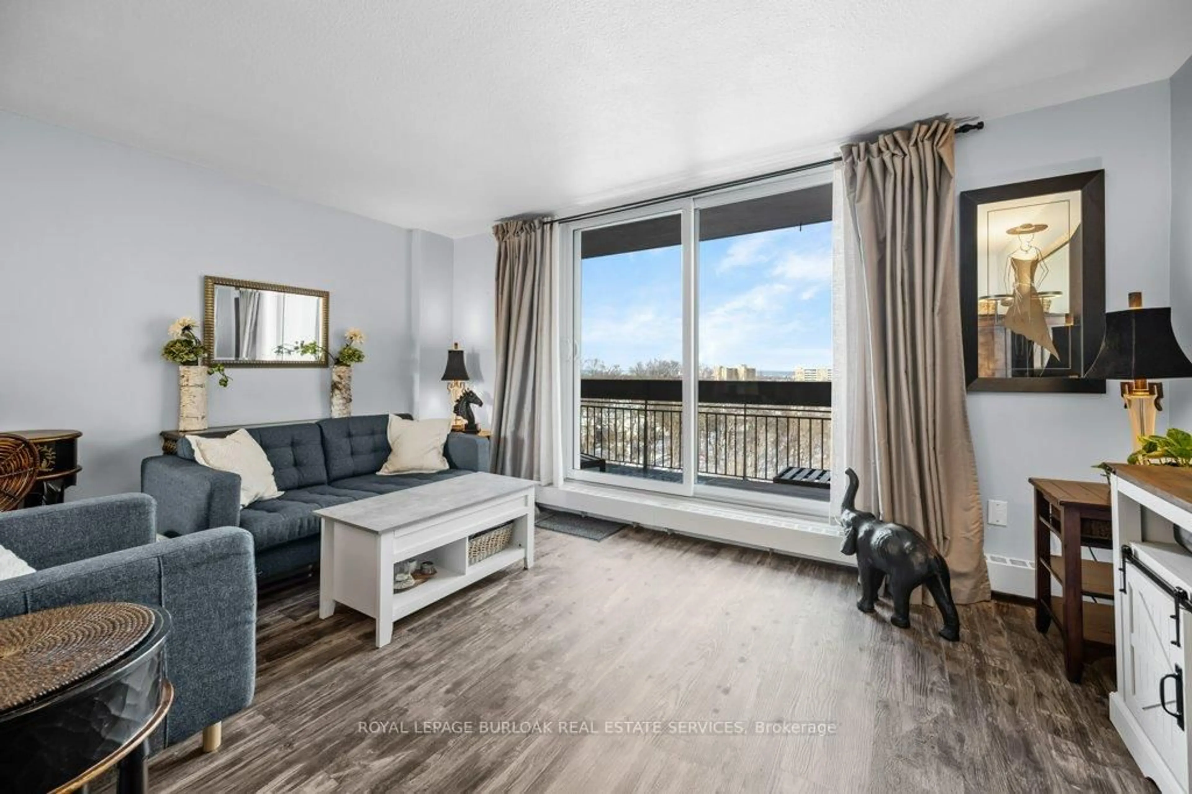 Living room with furniture, wood/laminate floor for 350 Quigley Rd #522, Hamilton Ontario L8K 5N2