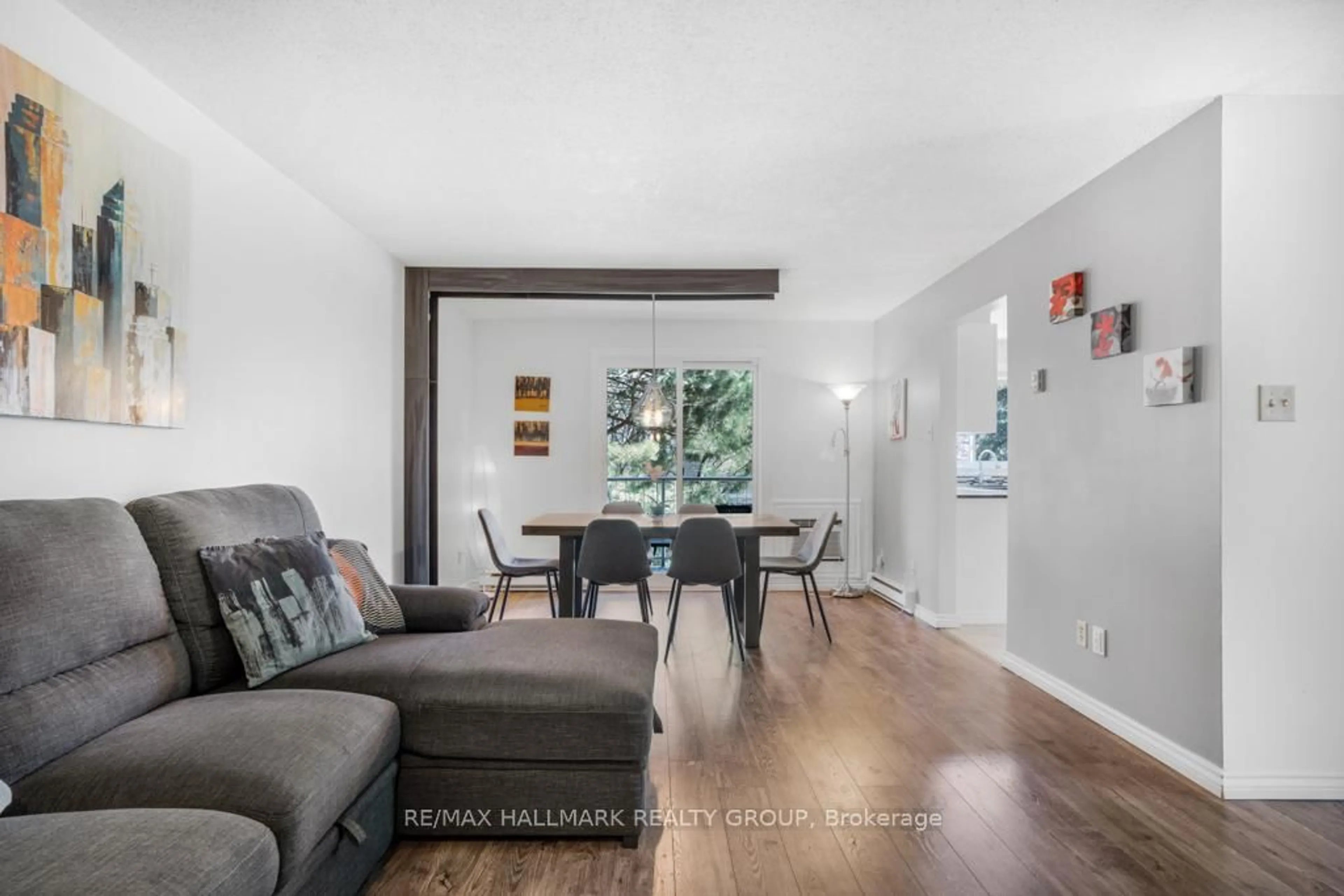 Living room with furniture, wood/laminate floor for 270 Brittany Dr #203, Ottawa Ontario K1K 4M3