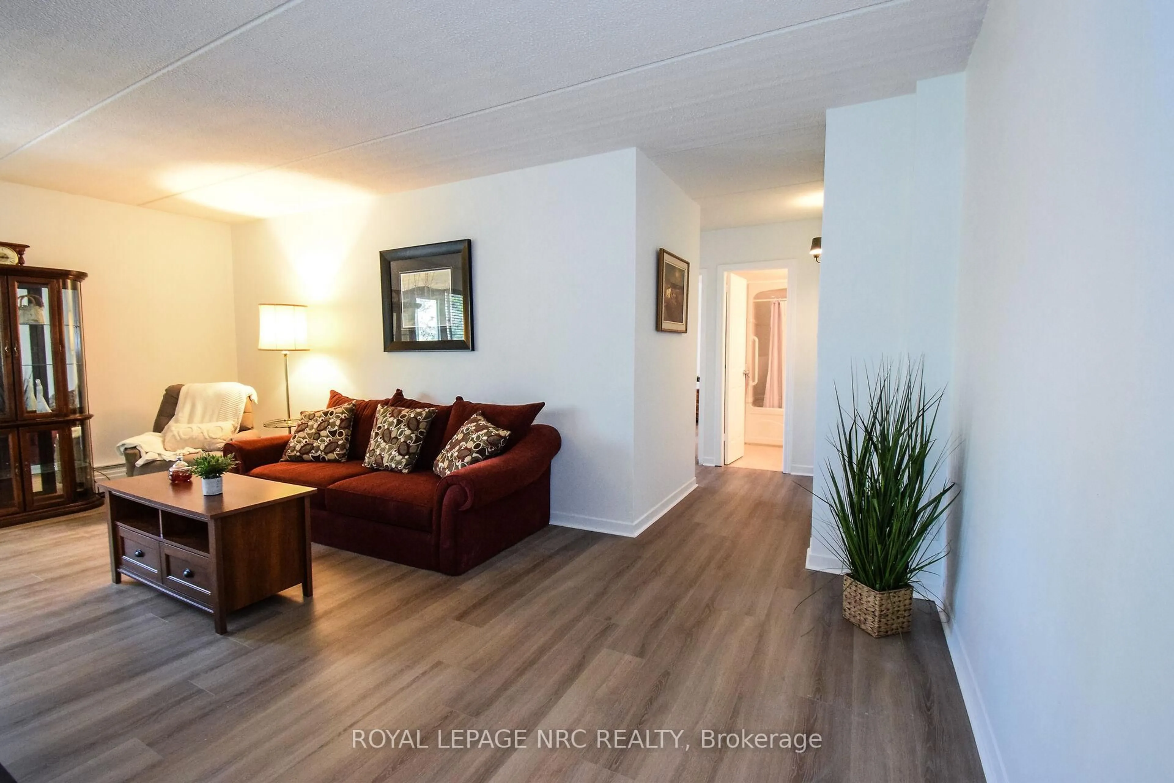 Living room with furniture, wood/laminate floor for 198 Scott St #305, St. Catharines Ontario L2N 5T3