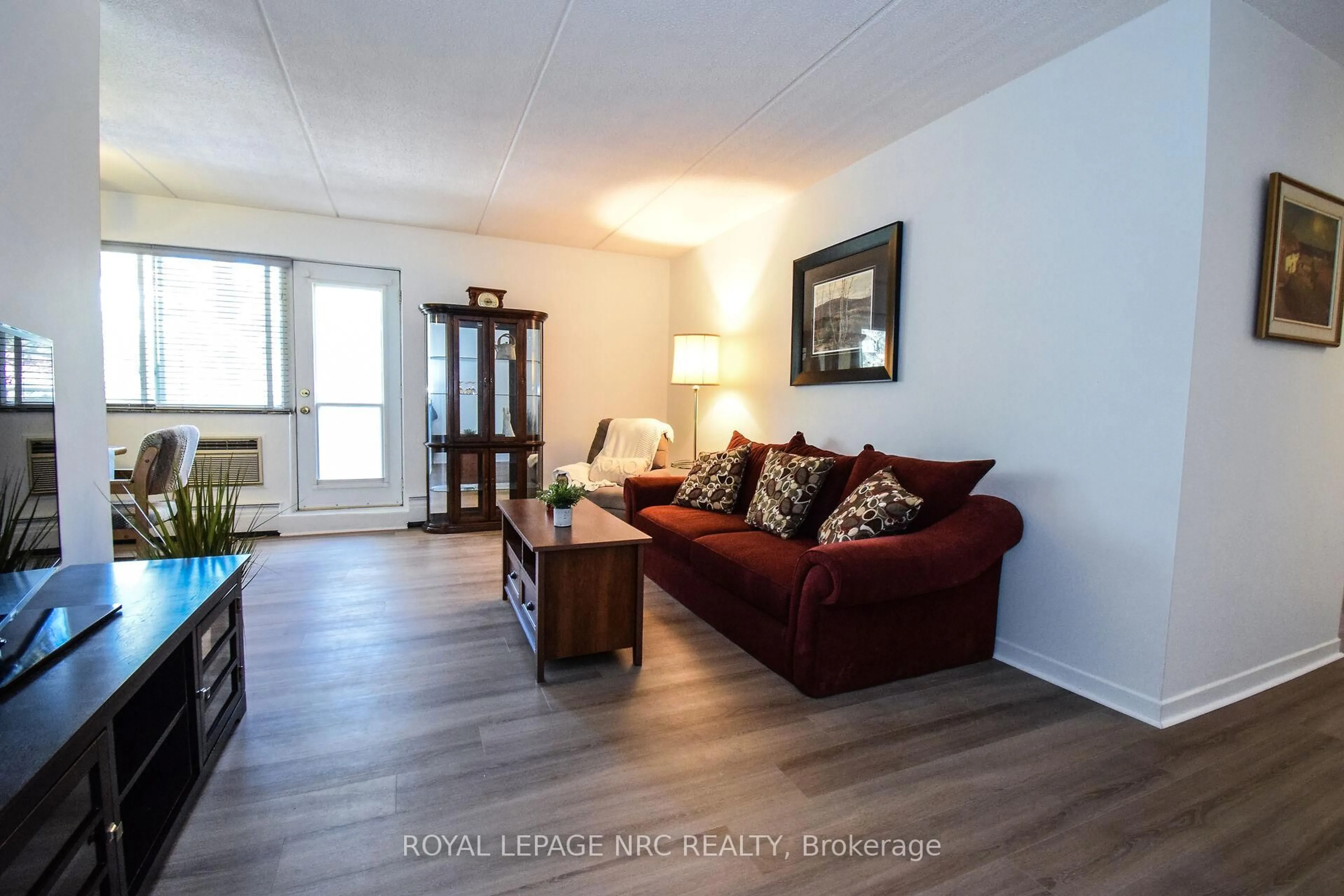 Living room with furniture, wood/laminate floor for 198 Scott St #305, St. Catharines Ontario L2N 5T3