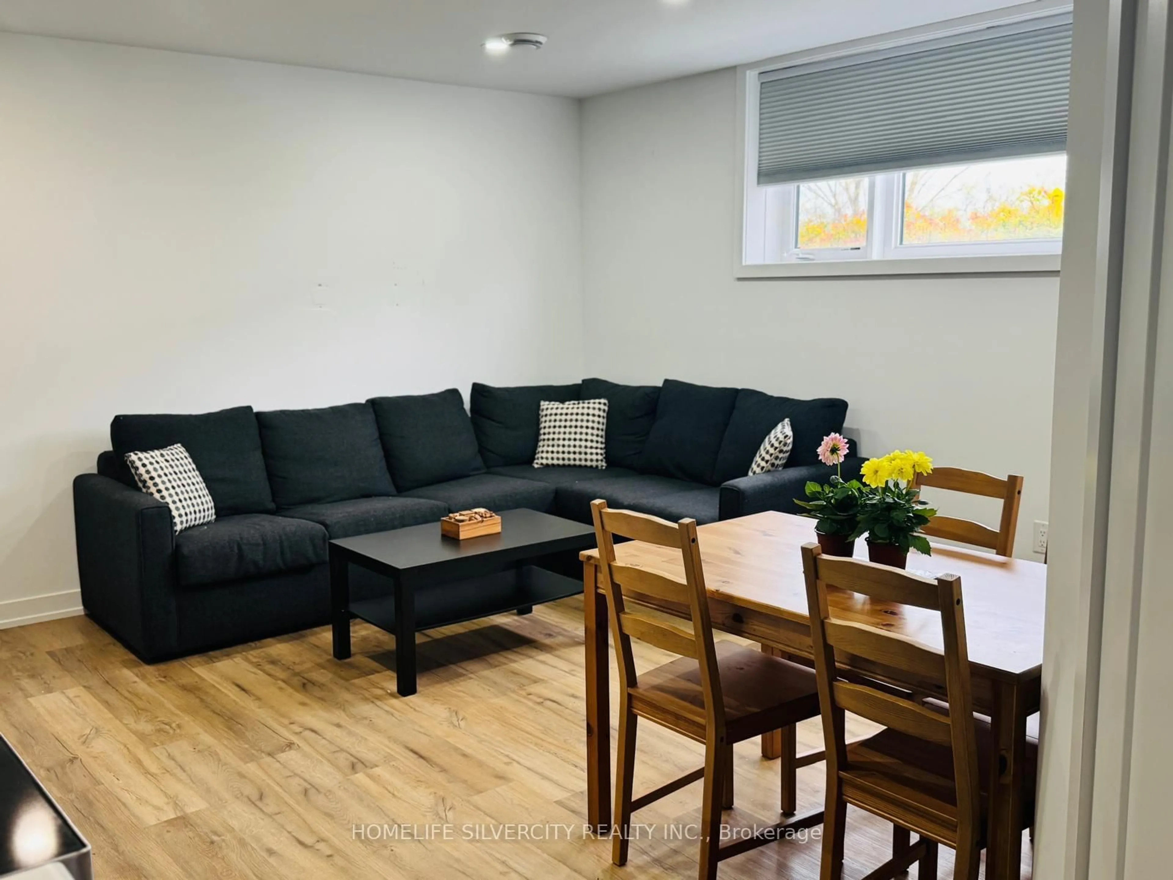 Living room with furniture, wood/laminate floor for 4263 Fourth Ave #211, Niagara Falls Ontario L2E 0C2