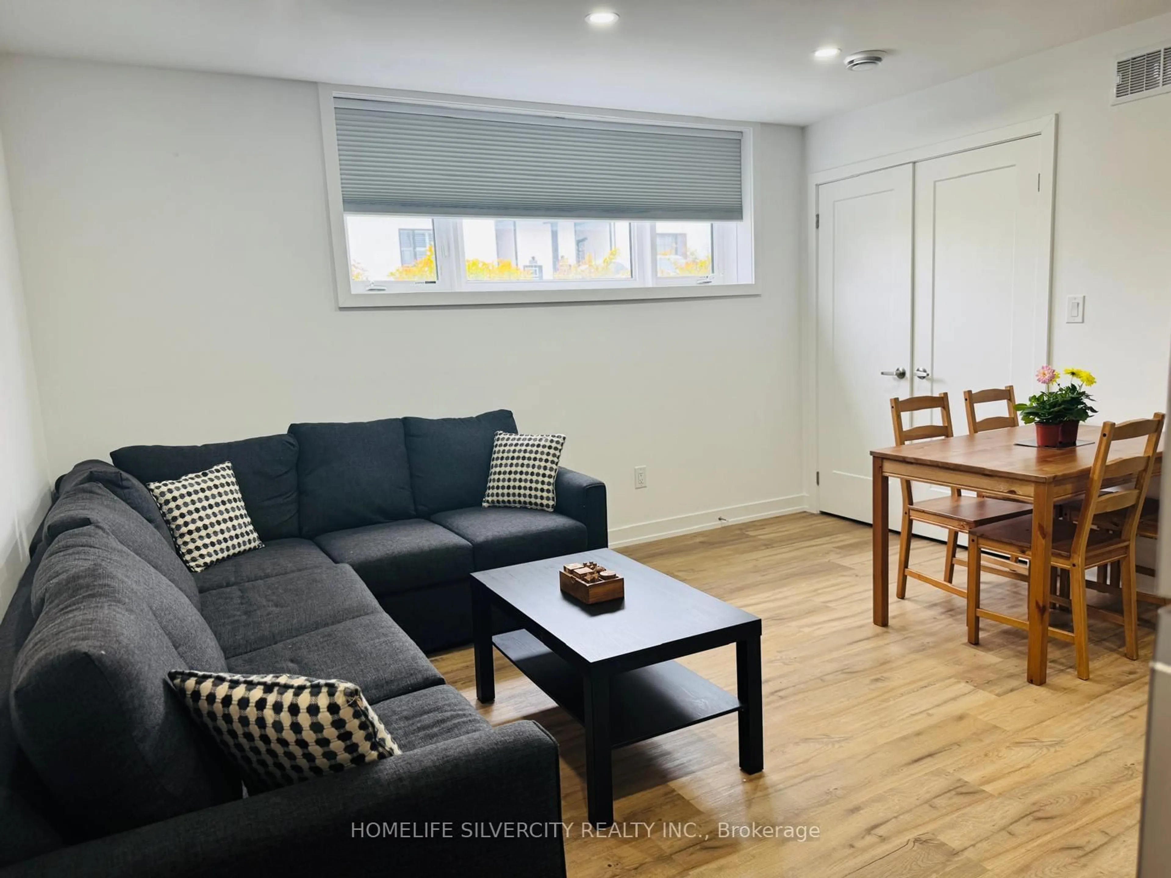 Living room with furniture, wood/laminate floor for 4263 Fourth Ave #211, Niagara Falls Ontario L2E 0C2