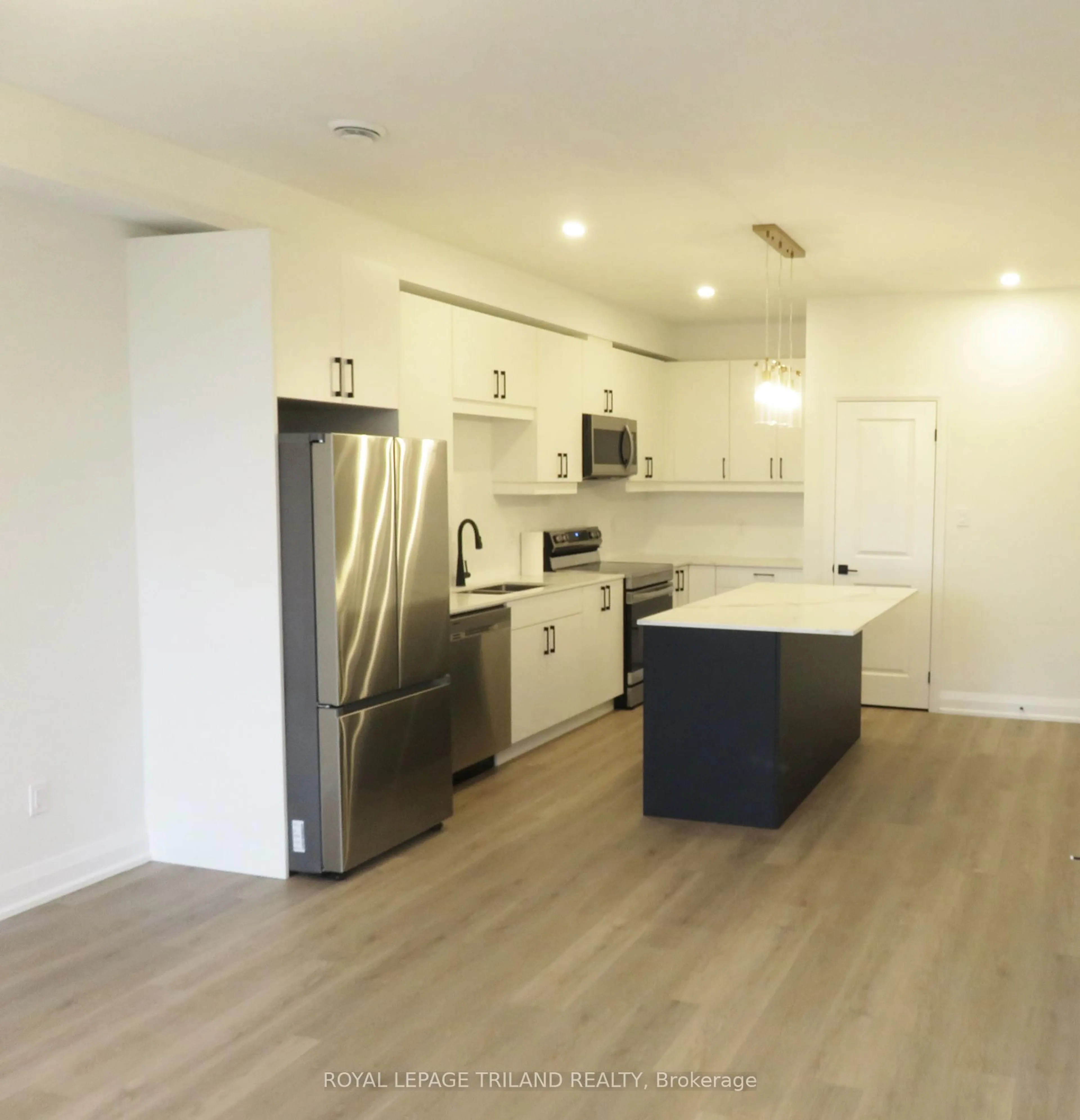 Open concept kitchen, wood/laminate floor for 3900 Savoy St #203, London South Ontario N6P 0A3