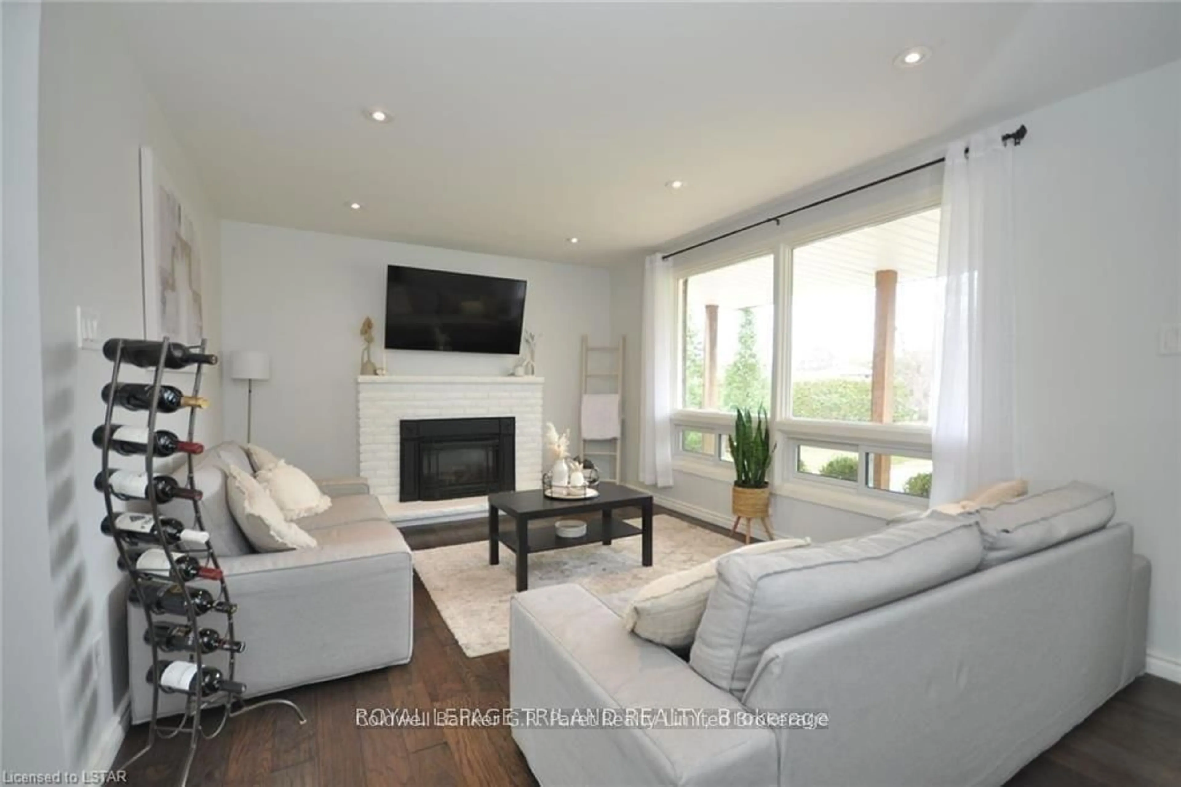 Living room with furniture, wood/laminate floor for 104 Simcoe Cres, Middlesex Centre Ontario N0L 1R0