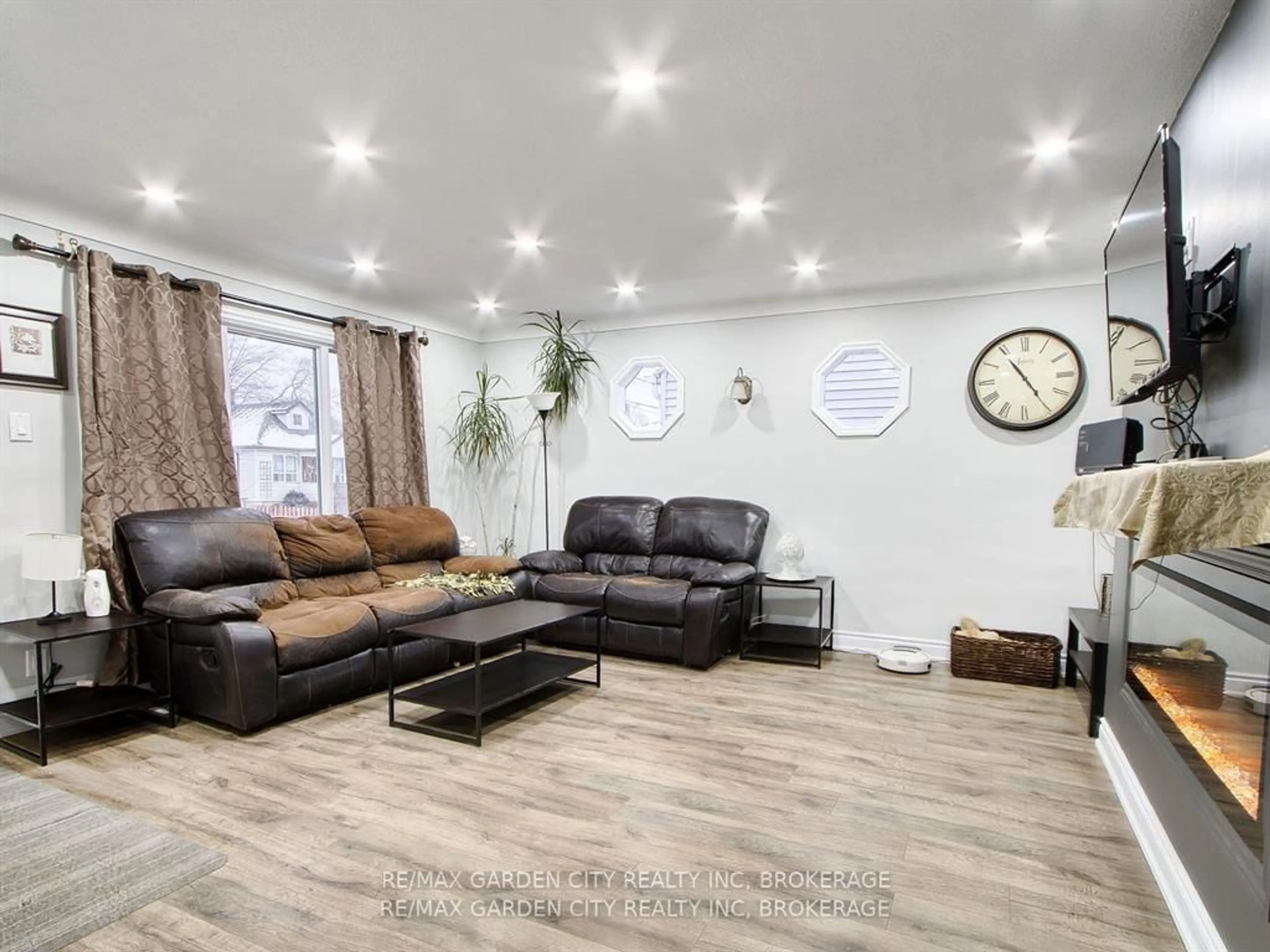 Living room with furniture, wood/laminate floor for 68 Carlton St, St. Catharines Ontario L2R 1P8