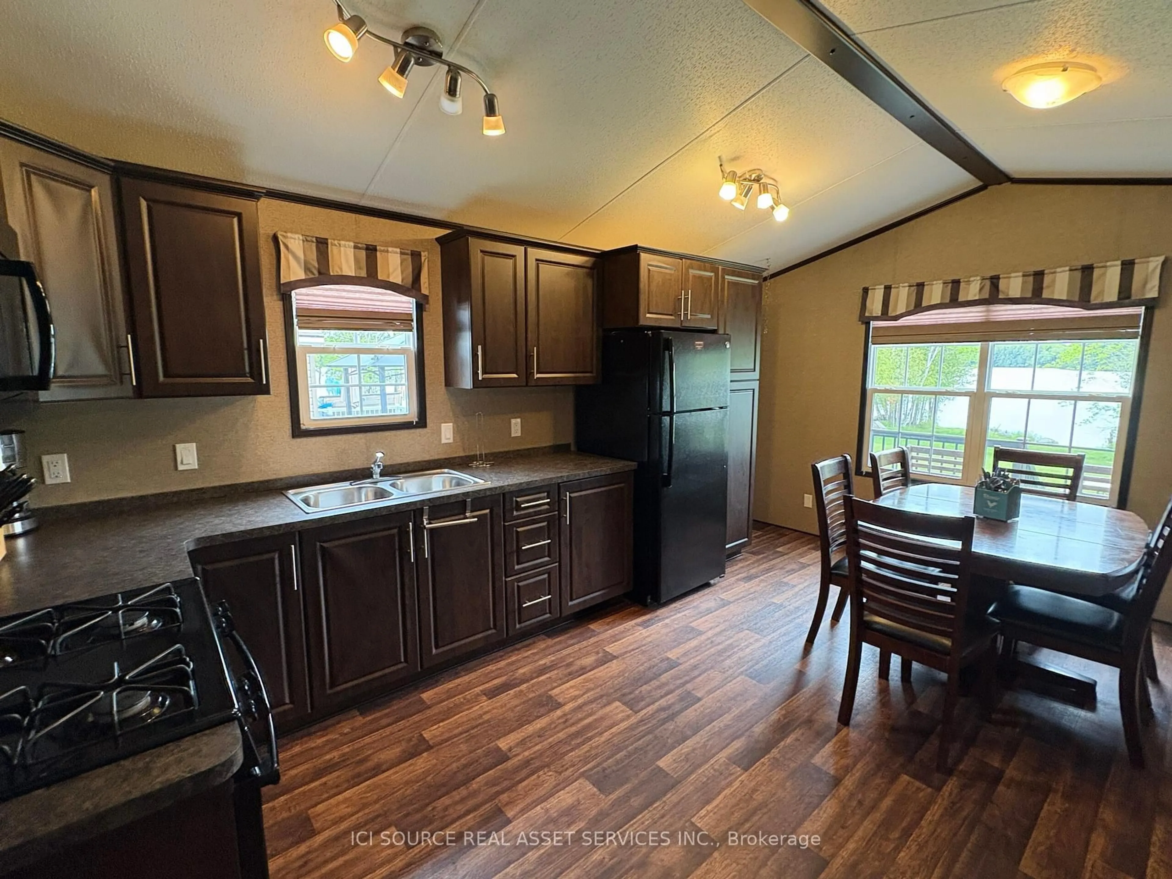 Open concept kitchen, wood/laminate floor for 1047 Bonnie Lake Camp Rd #MNB03, Bracebridge Ontario P1L 1W9
