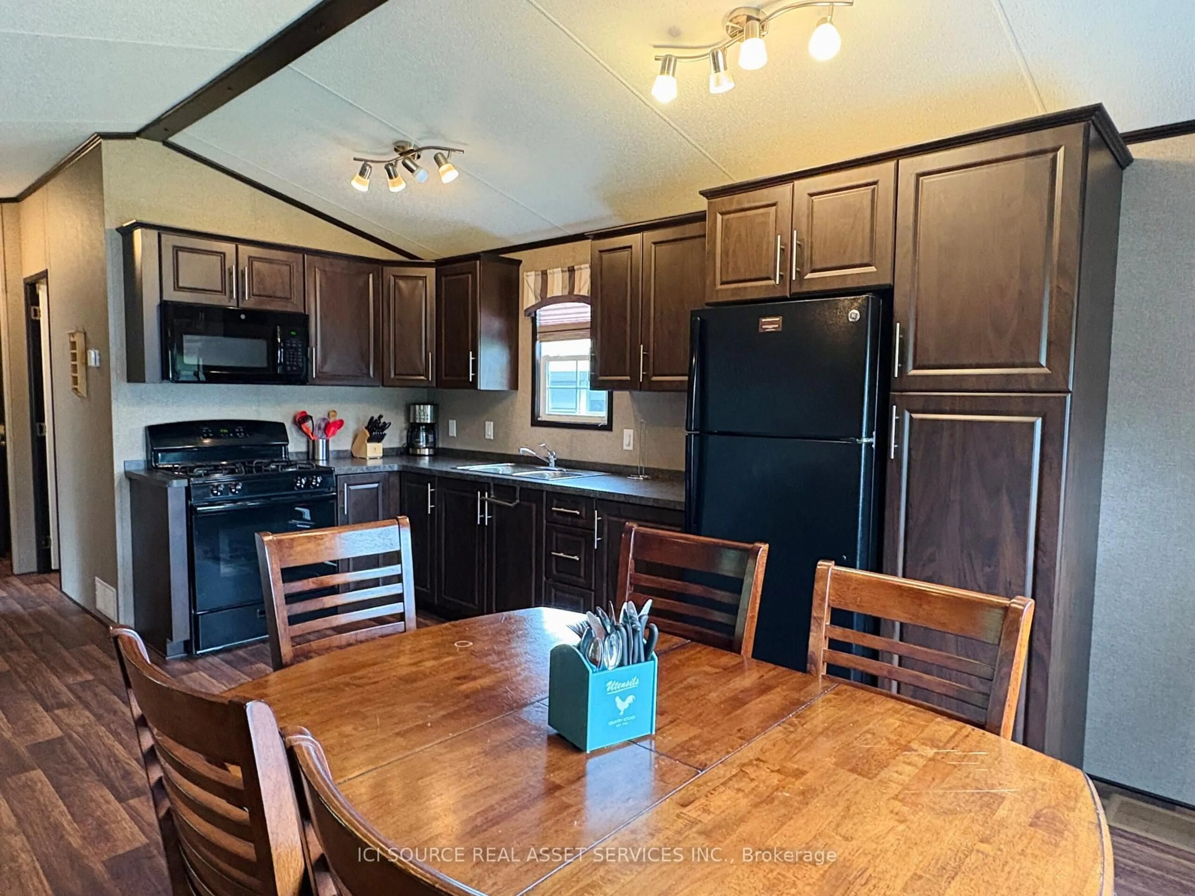 Open concept kitchen, wood/laminate floor for 1047 Bonnie Lake Camp Rd #MNB03, Bracebridge Ontario P1L 1W9