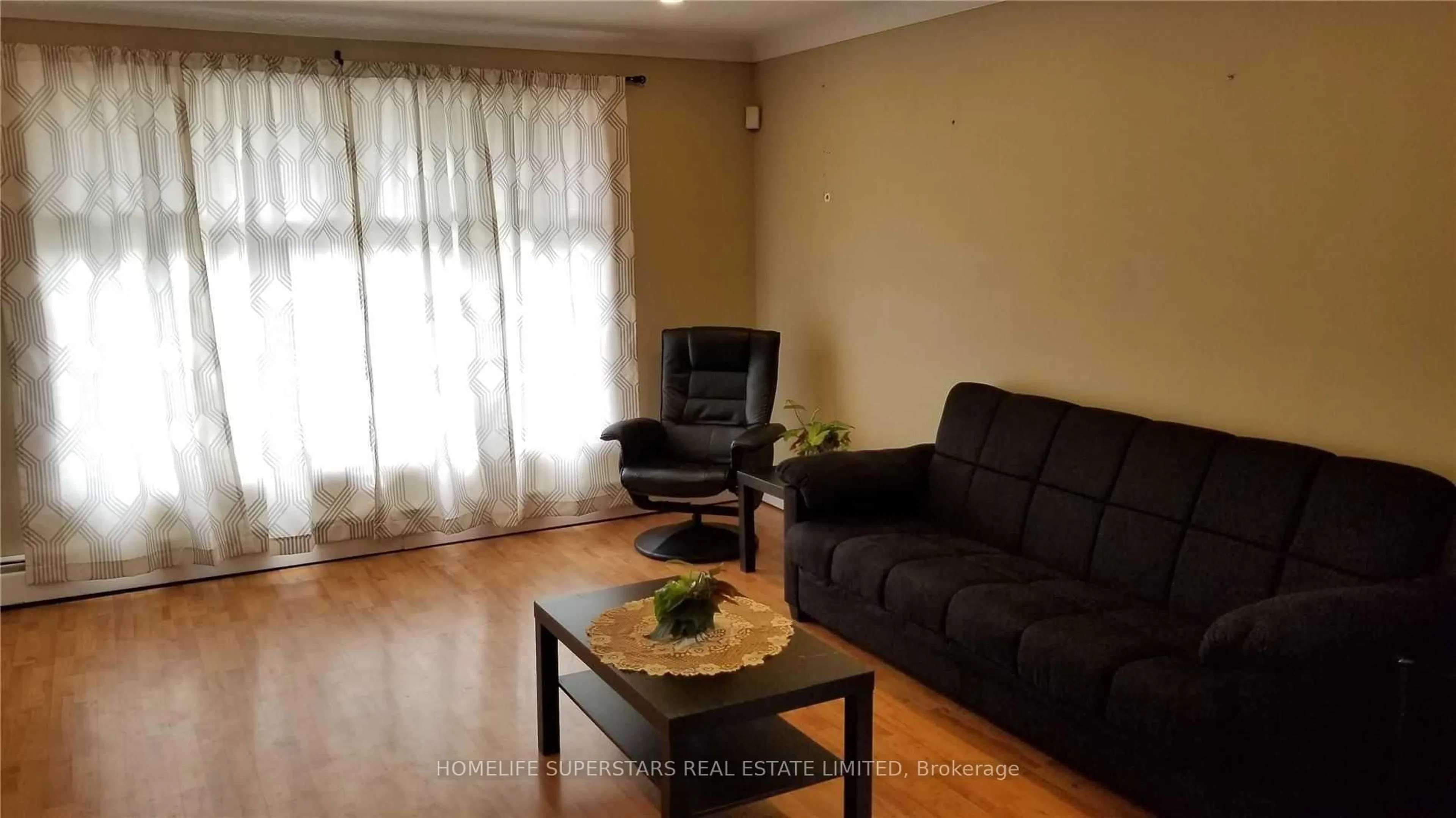 Living room with furniture, wood/laminate floor for 5532 Drummond Rd, Niagara Falls Ontario L2G 4L3