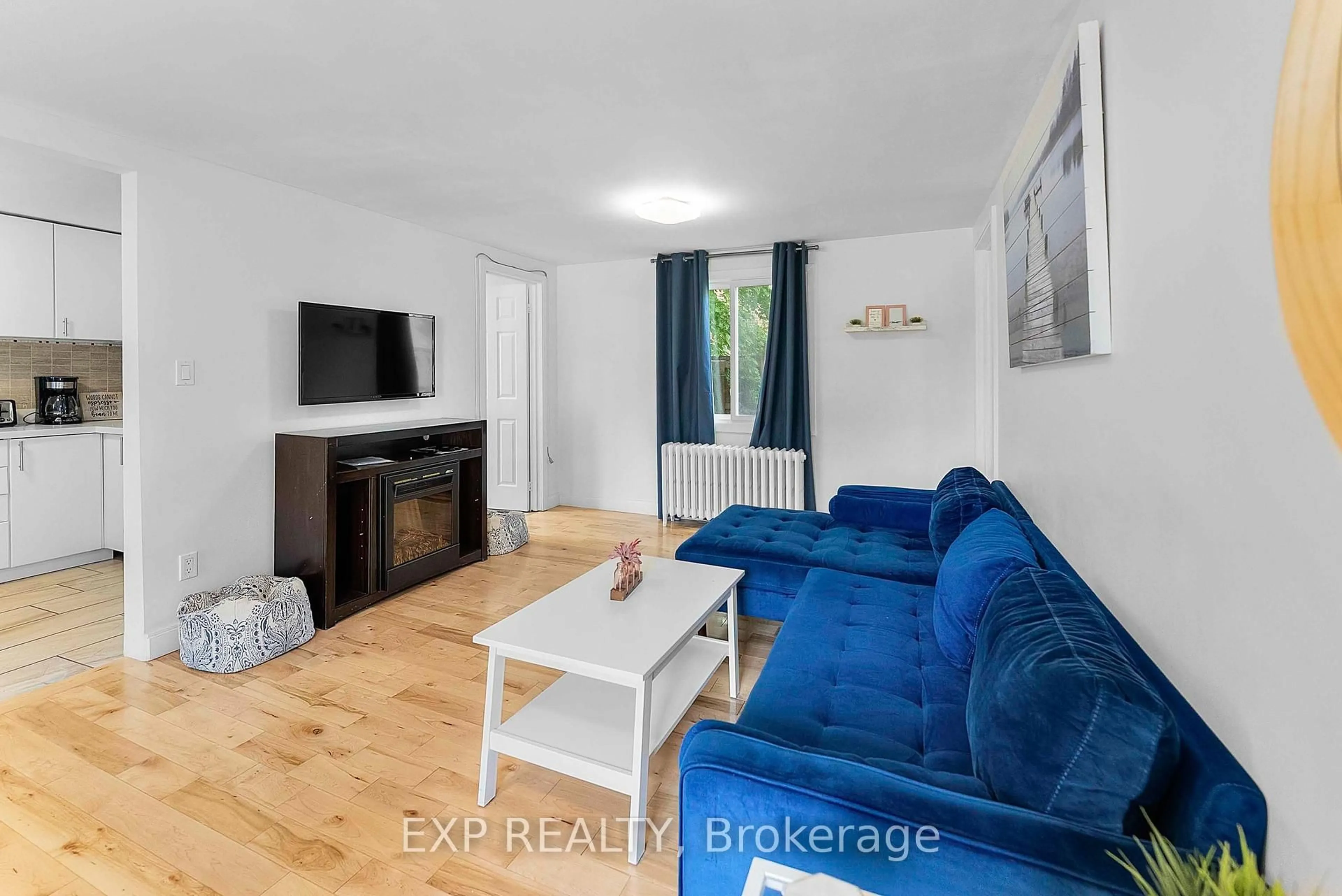 Living room with furniture, wood/laminate floor for 6141 Mcleod Rd, Niagara Falls Ontario L2G 3E7