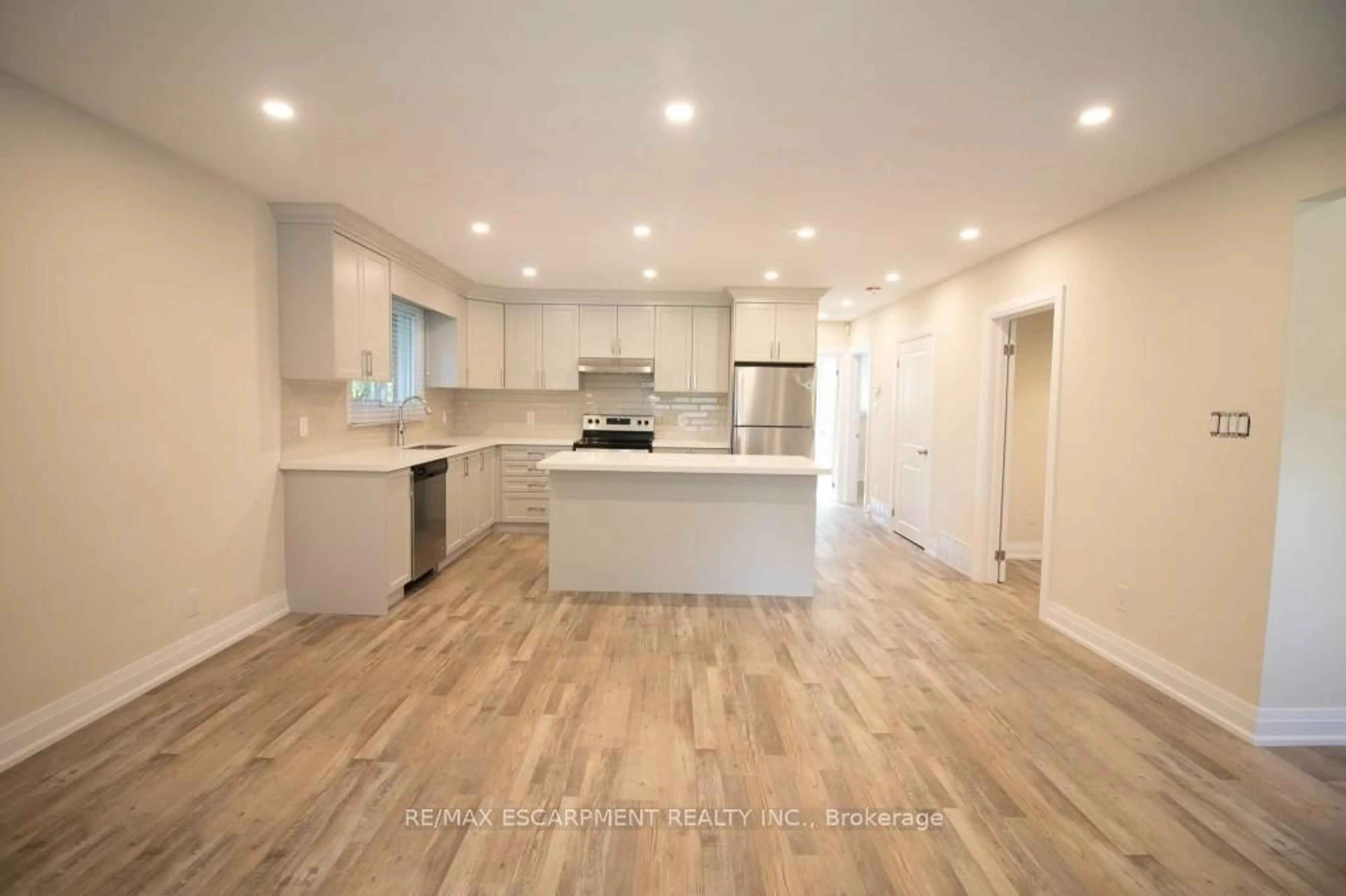 Open concept kitchen, wood/laminate floor for 130 West 34th St, Hamilton Ontario L9C 5K3