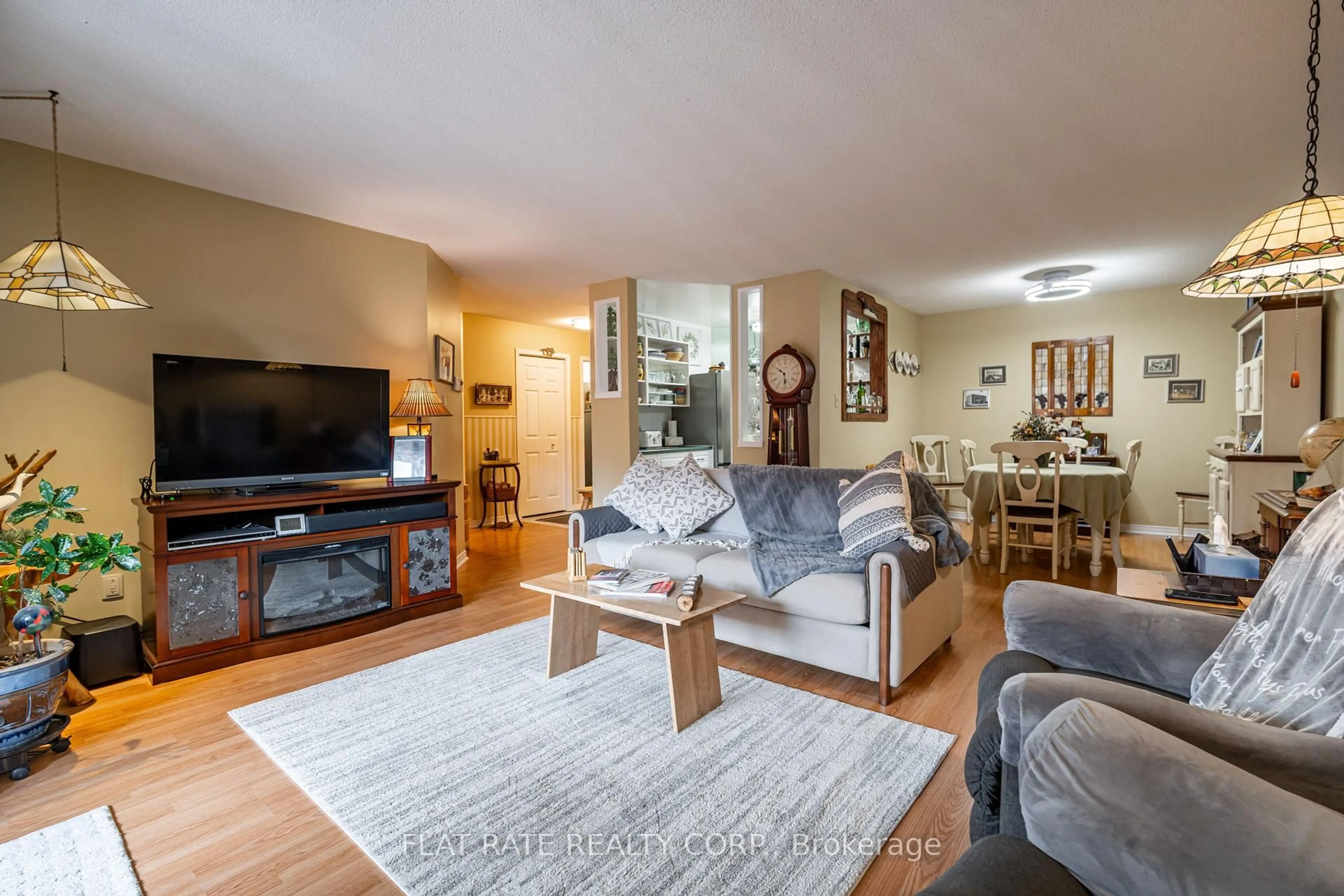 Living room with furniture, wood/laminate floor for 475 Parkhill Rd #215, Peterborough Central Ontario K9H 7M5