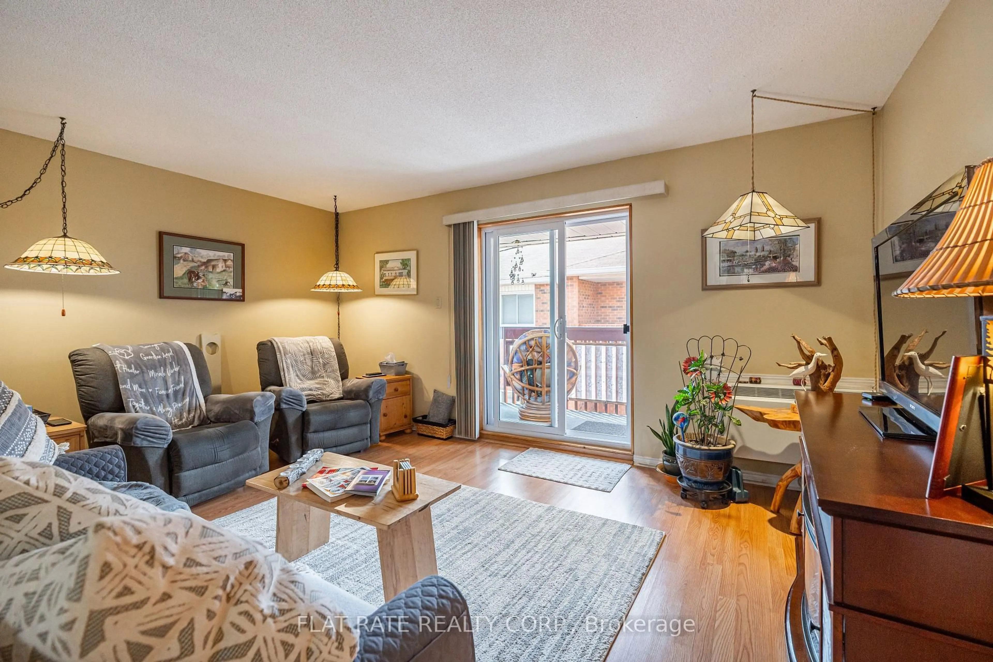 Living room with furniture, wood/laminate floor for 475 Parkhill Rd #215, Peterborough Central Ontario K9H 7M5