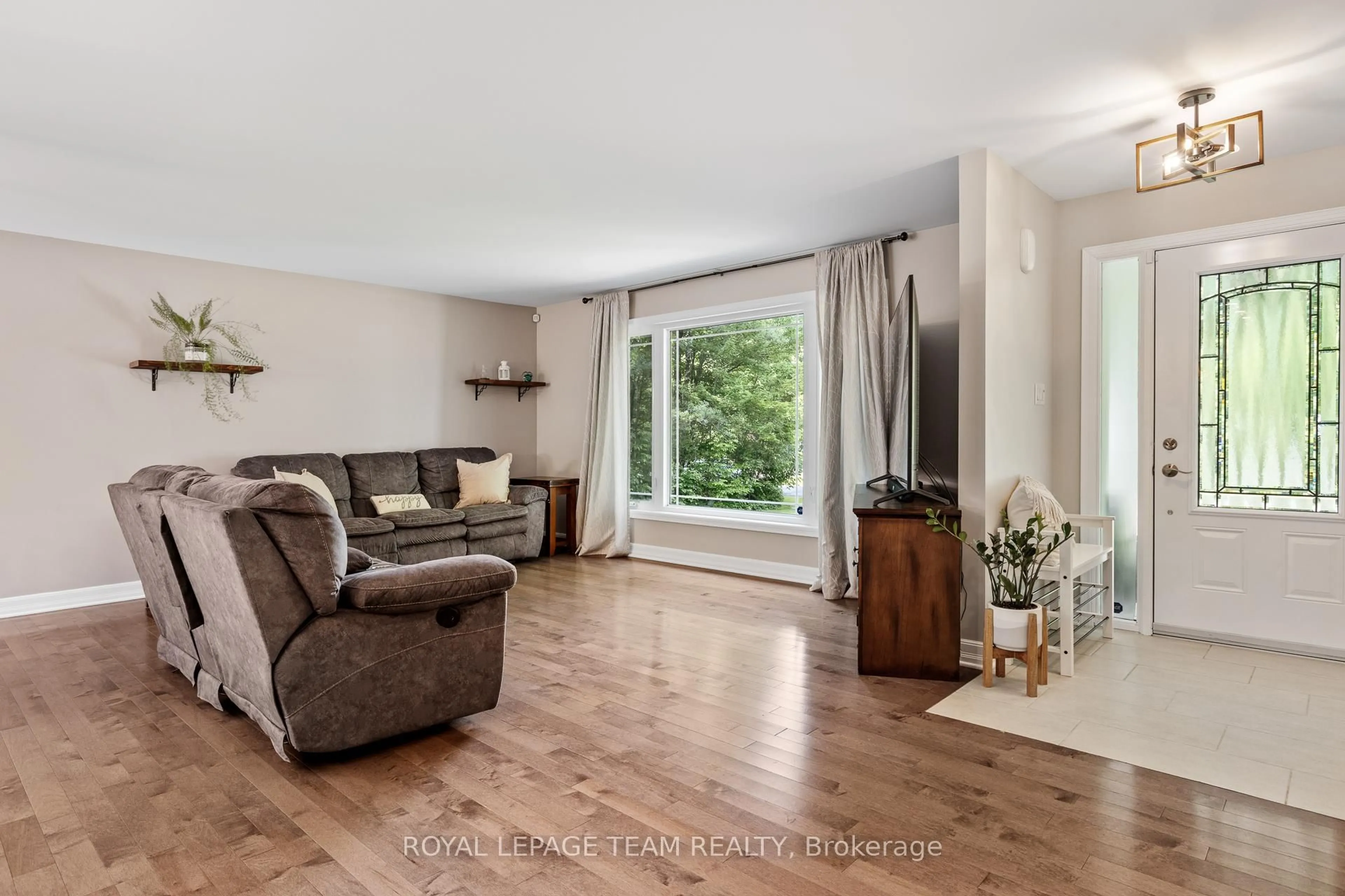 Living room with furniture, wood/laminate floor for 3301 Wild Cherry Dr, Osgoode Ontario K0A 2W0