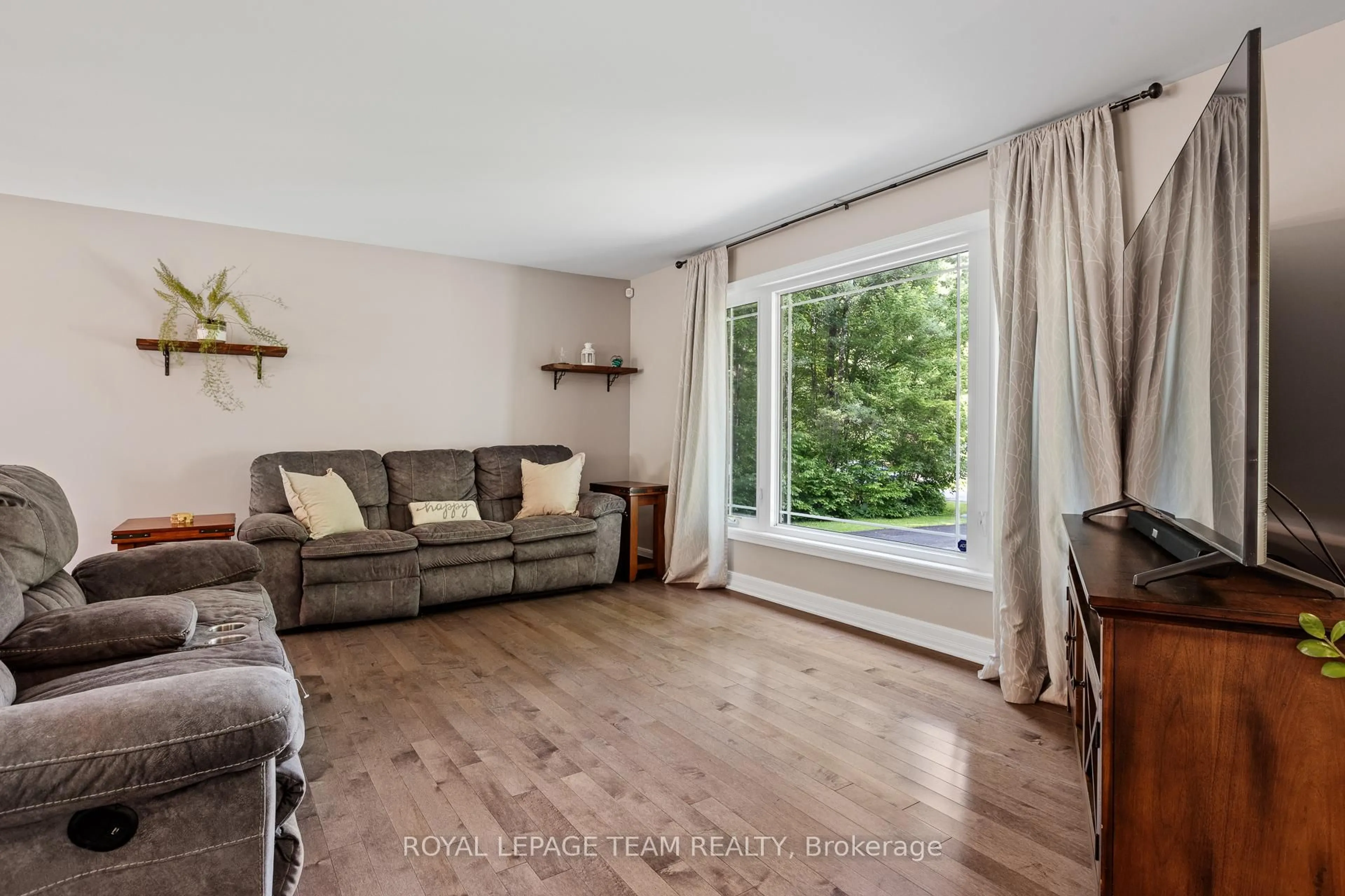 Living room with furniture, wood/laminate floor for 3301 Wild Cherry Dr, Osgoode Ontario K0A 2W0