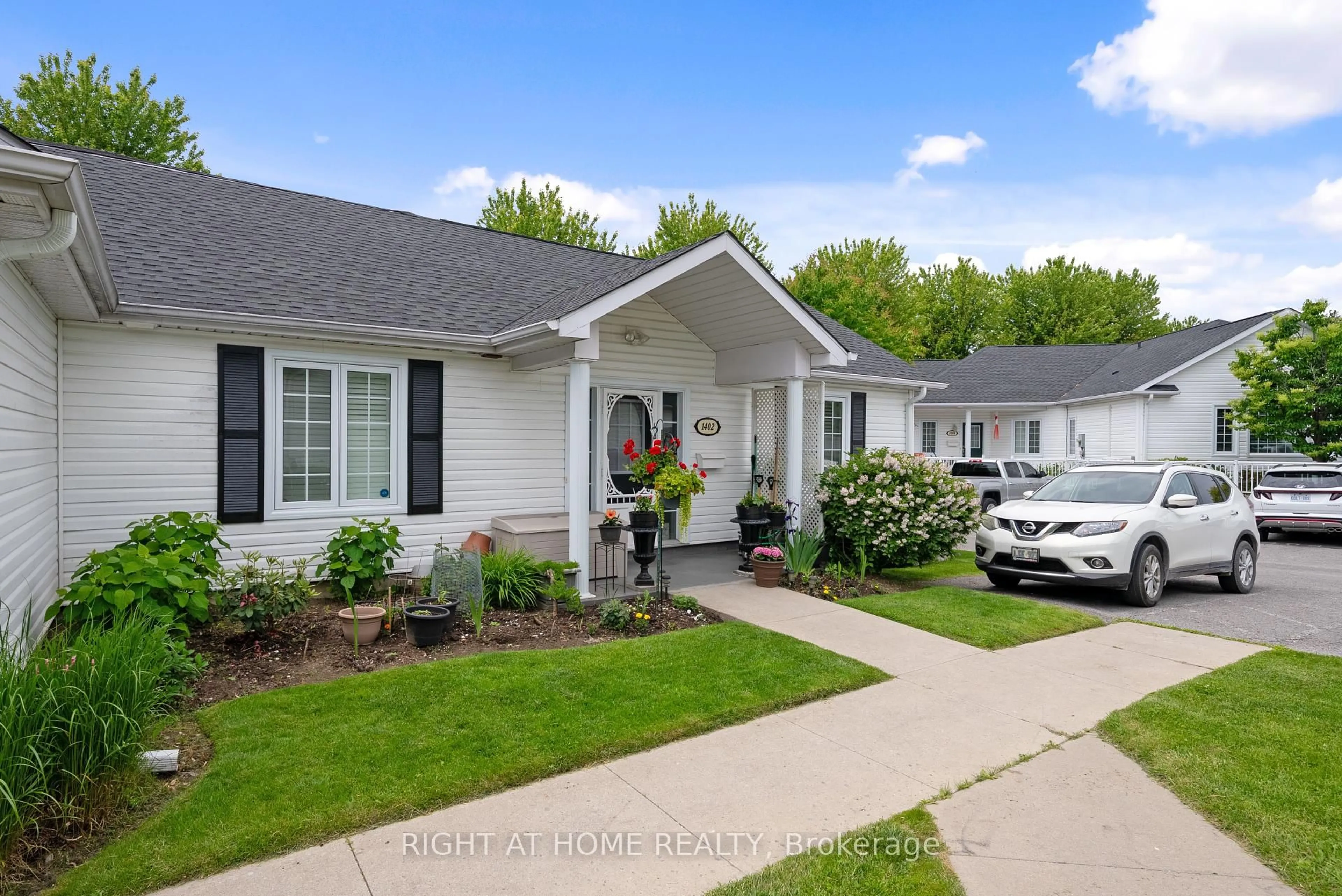 Home with vinyl exterior material, street for 1055 Birchwood Tr #1402, Cobourg Ontario K9A 5Y2