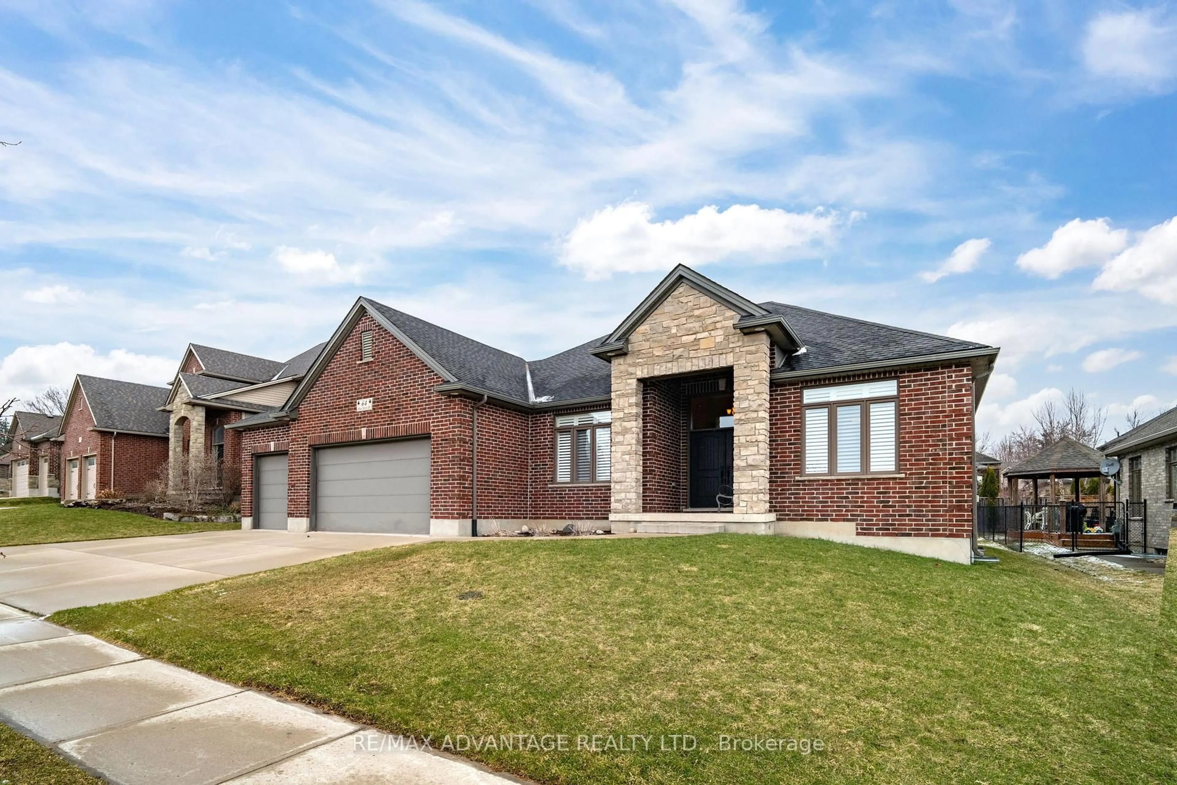 Home with brick exterior material, street for 64 Blue Heron Dr, Middlesex Centre Ontario N0M 2A0