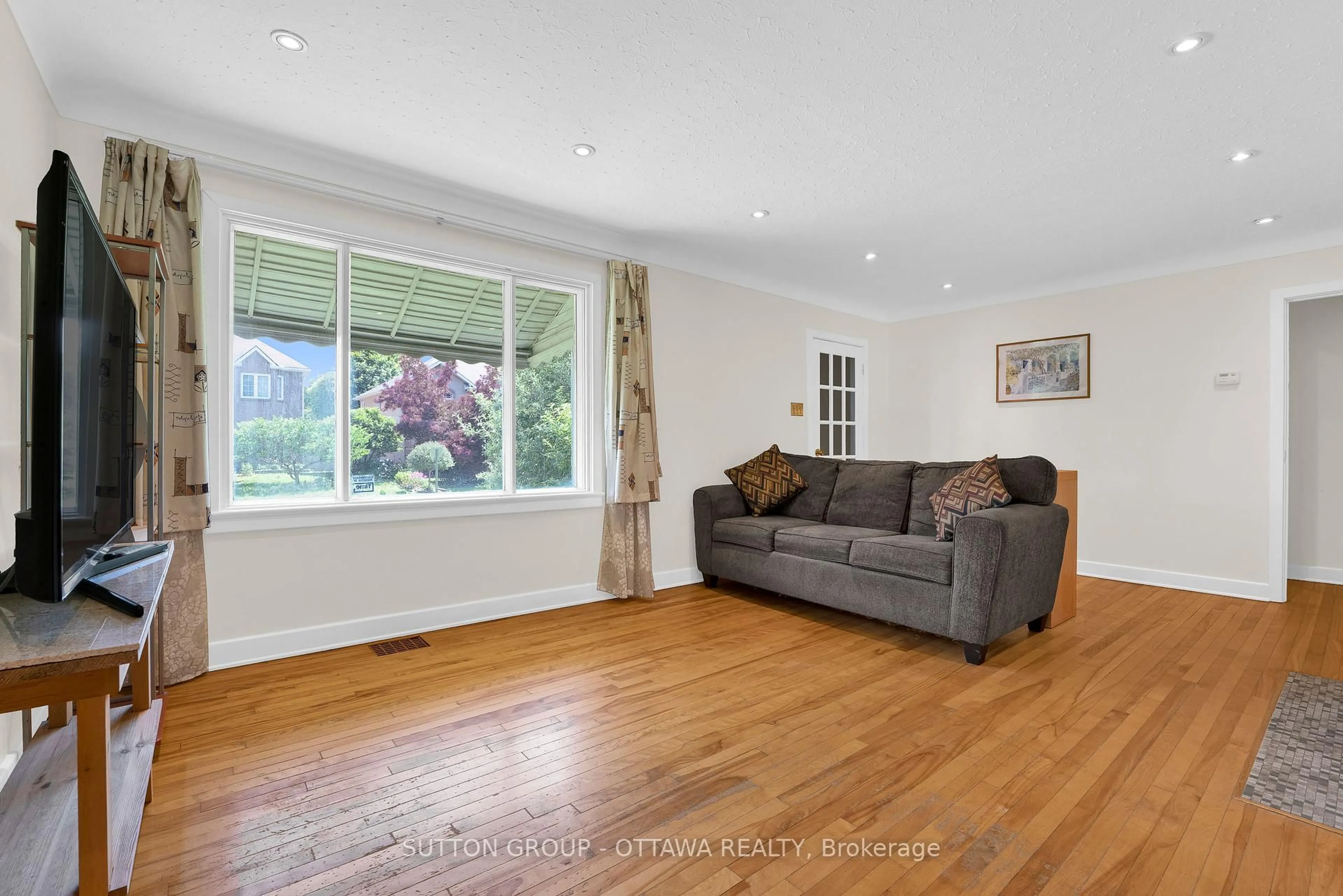 Living room with furniture, wood/laminate floor for 15 Granton Ave, Ottawa Ontario K2G 1W5