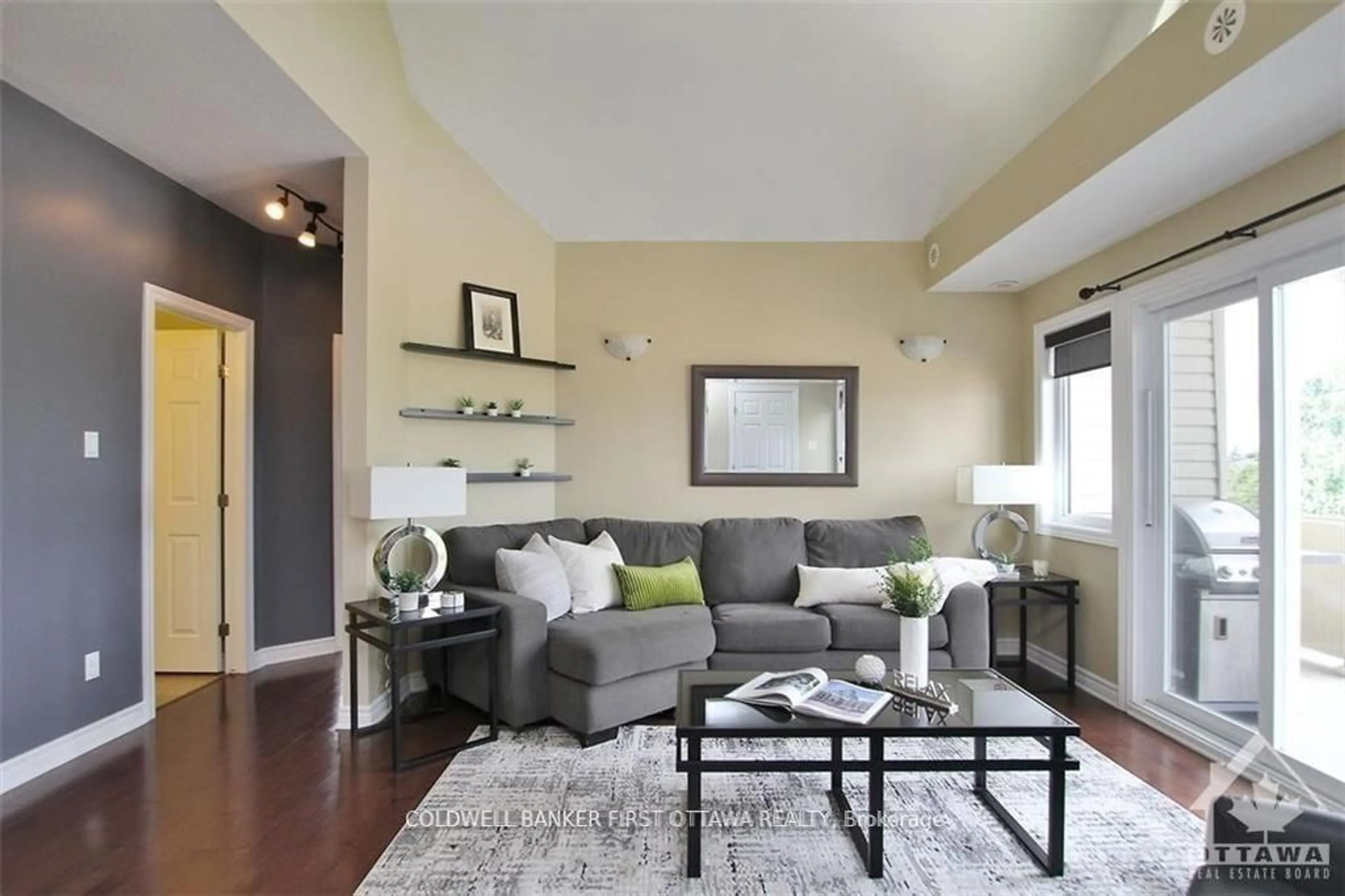 Living room with furniture, wood/laminate floor for 137 HARTHILL Way #E, Ottawa Ontario K2J 5V1