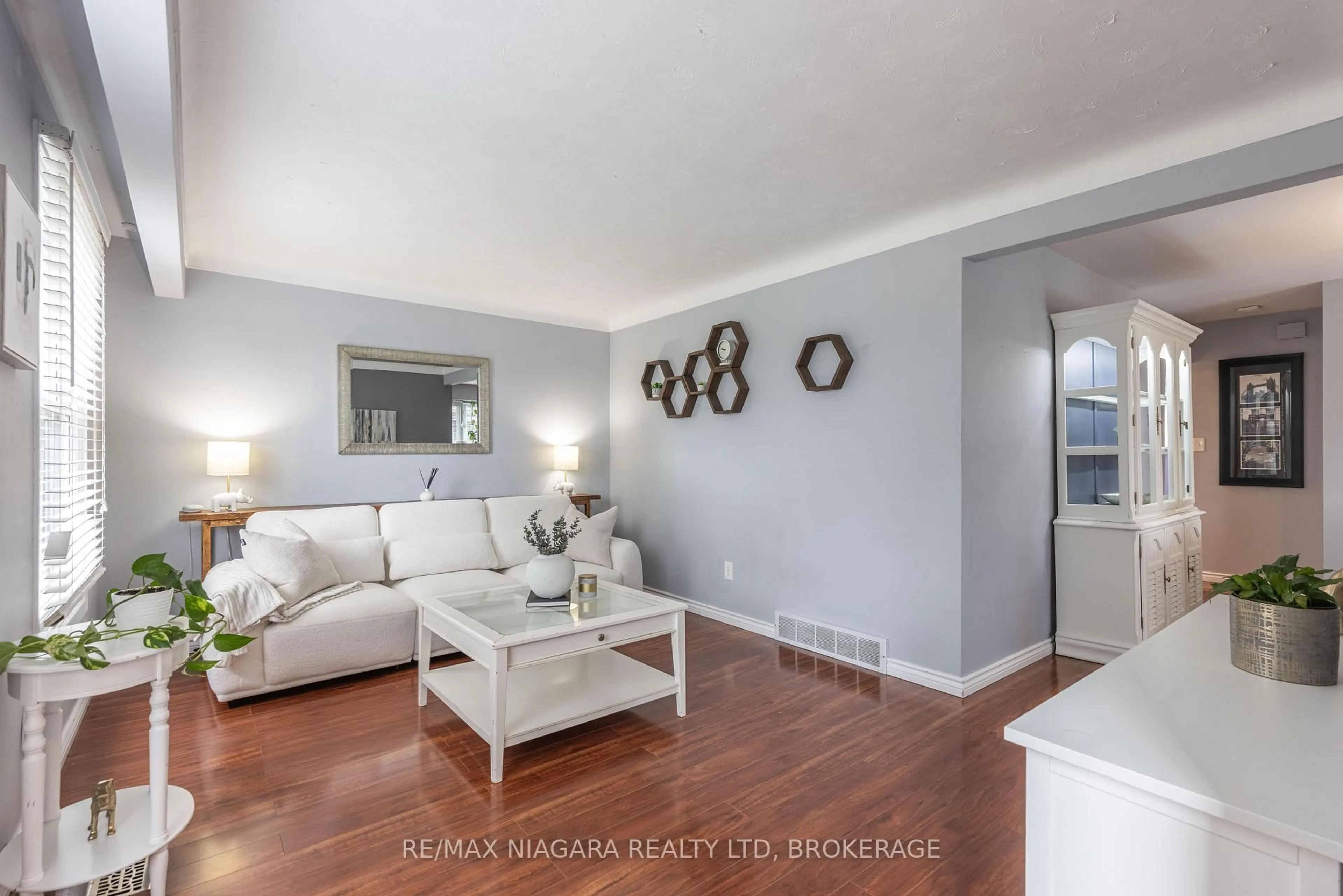 Living room with furniture, wood/laminate floor for 7012 Venus Cres, Niagara Falls Ontario L2G 7E9