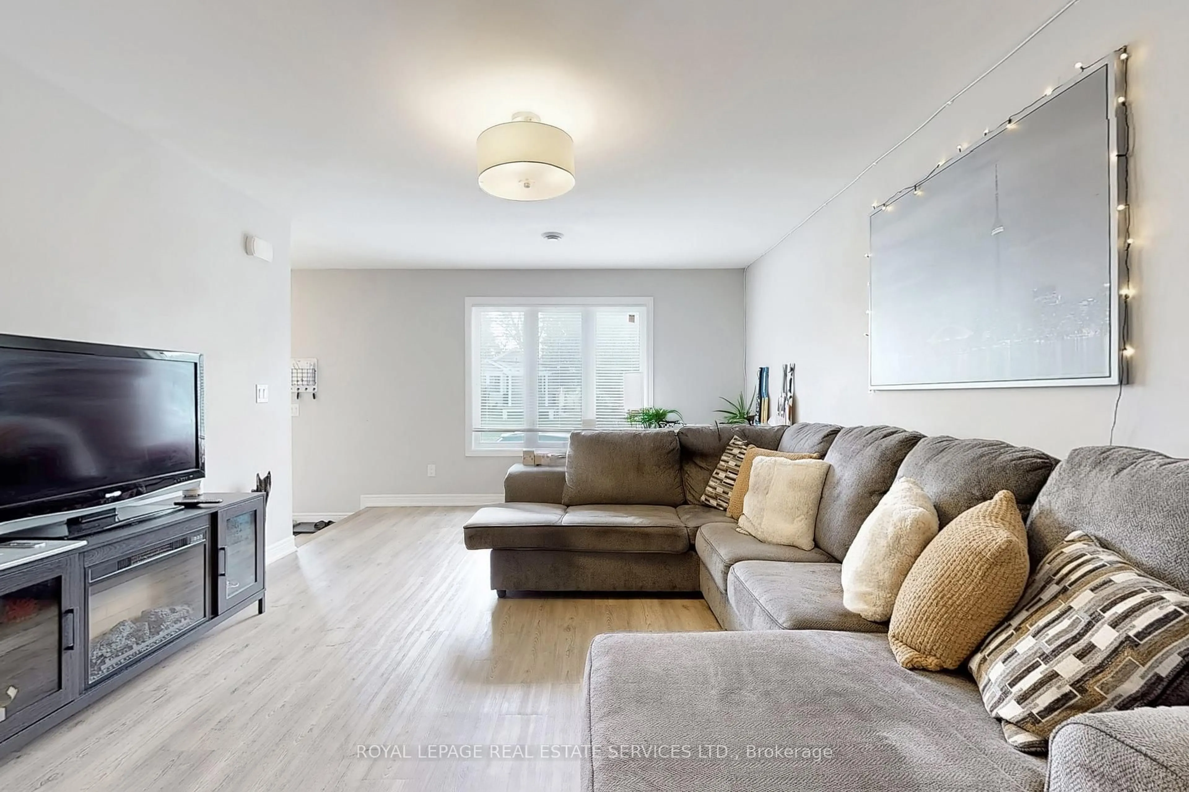 Living room with furniture, wood/laminate floor for 89 Louth St, St. Catharines Ontario L2S 2T7