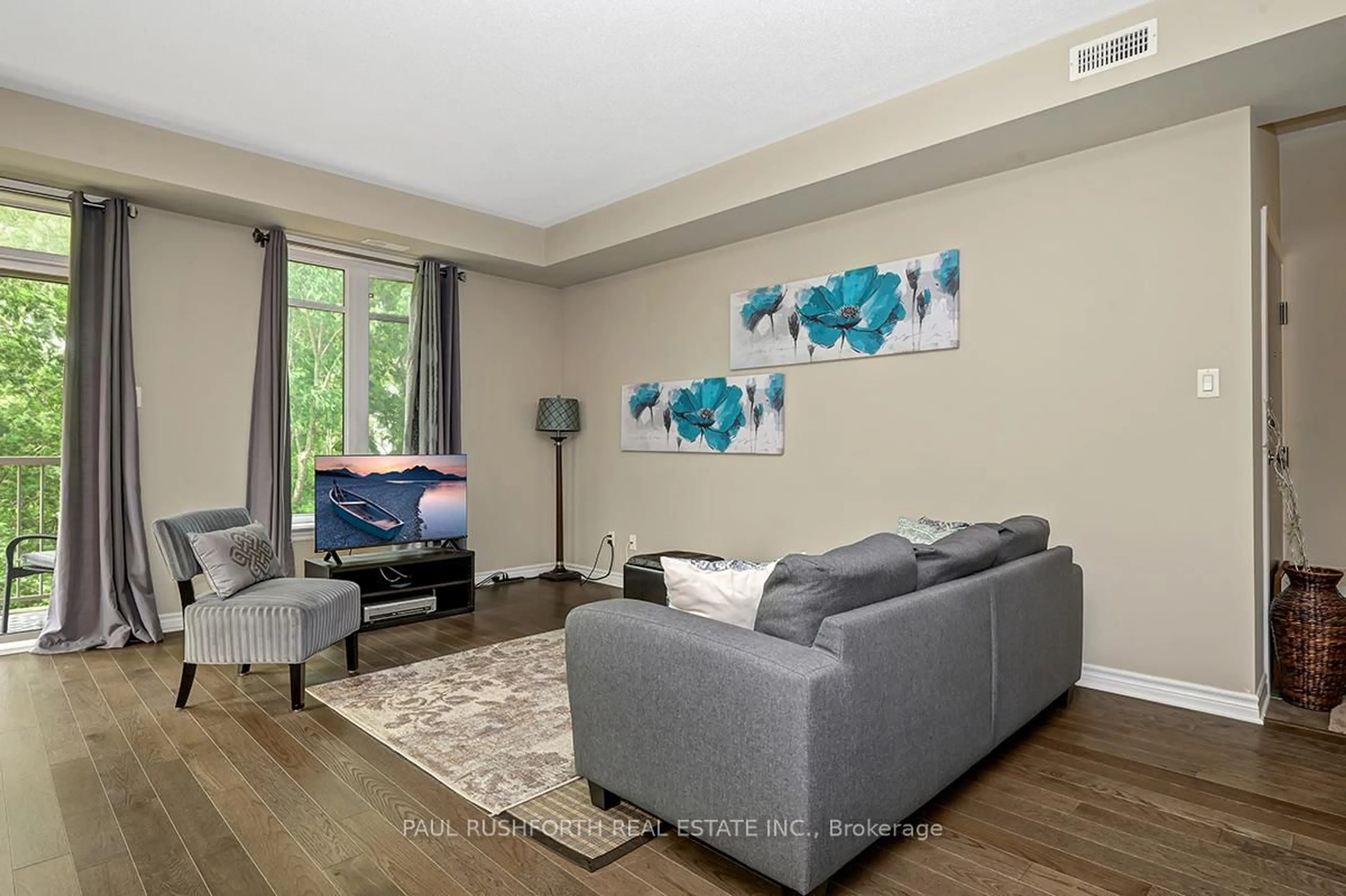 Living room with furniture, wood/laminate floor for 21 Tadley Private #F, Ottawa Ontario K2J 2T3