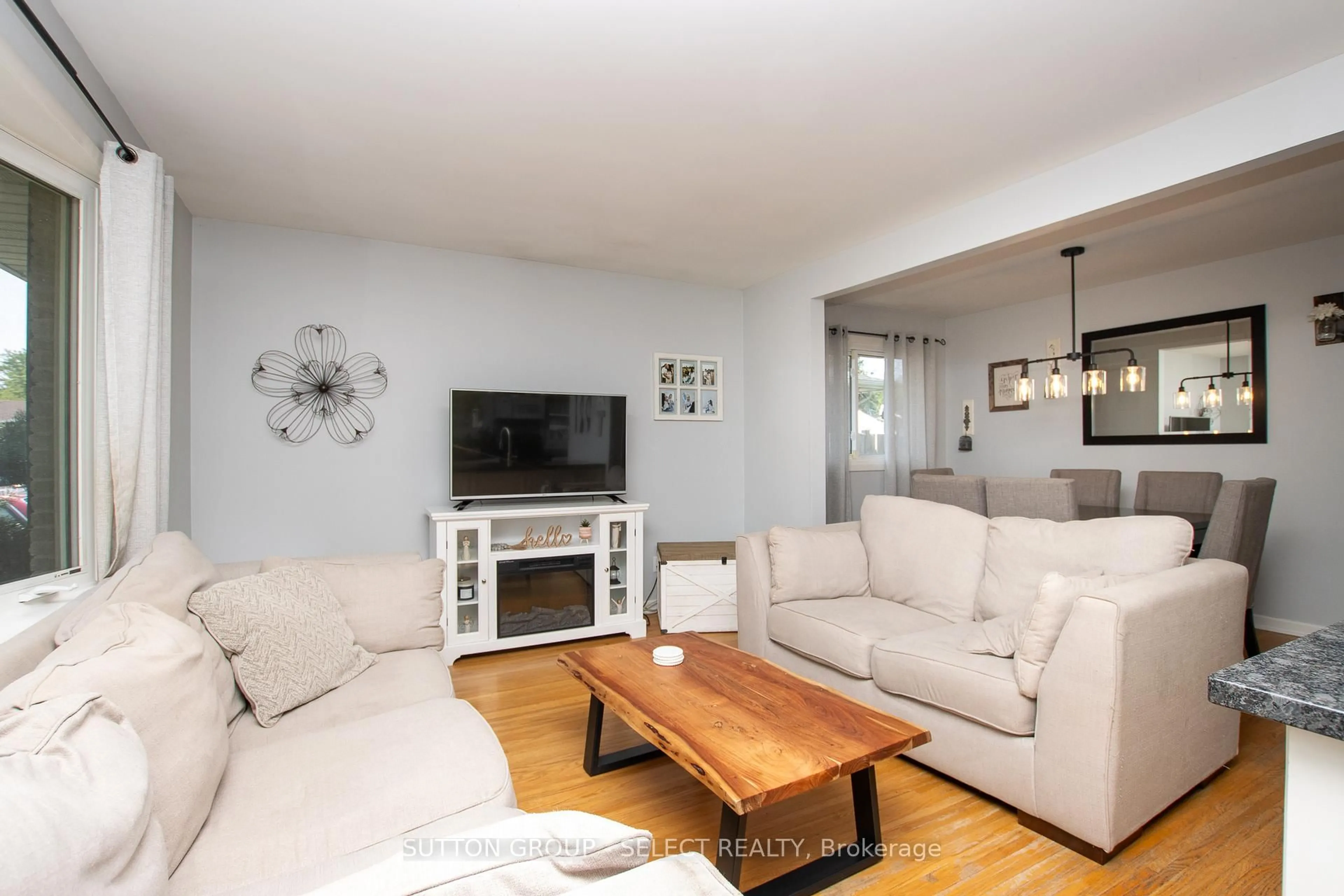 Living room with furniture, wood/laminate floor for 26 Surrey Crt, London South Ontario N6E 1T9