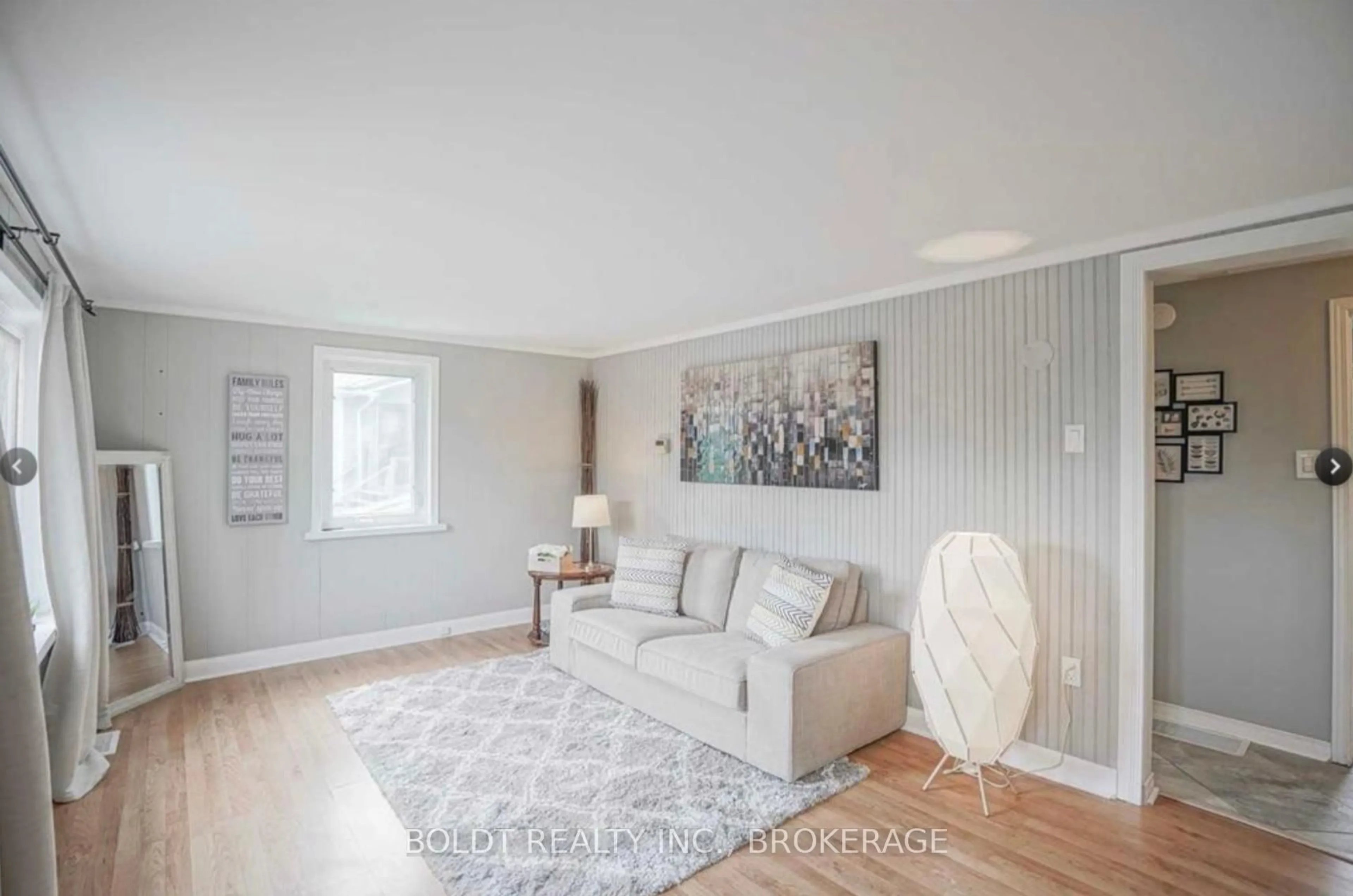 Living room with furniture, wood/laminate floor for 61 Bradley St, St. Catharines Ontario L3T 1R5