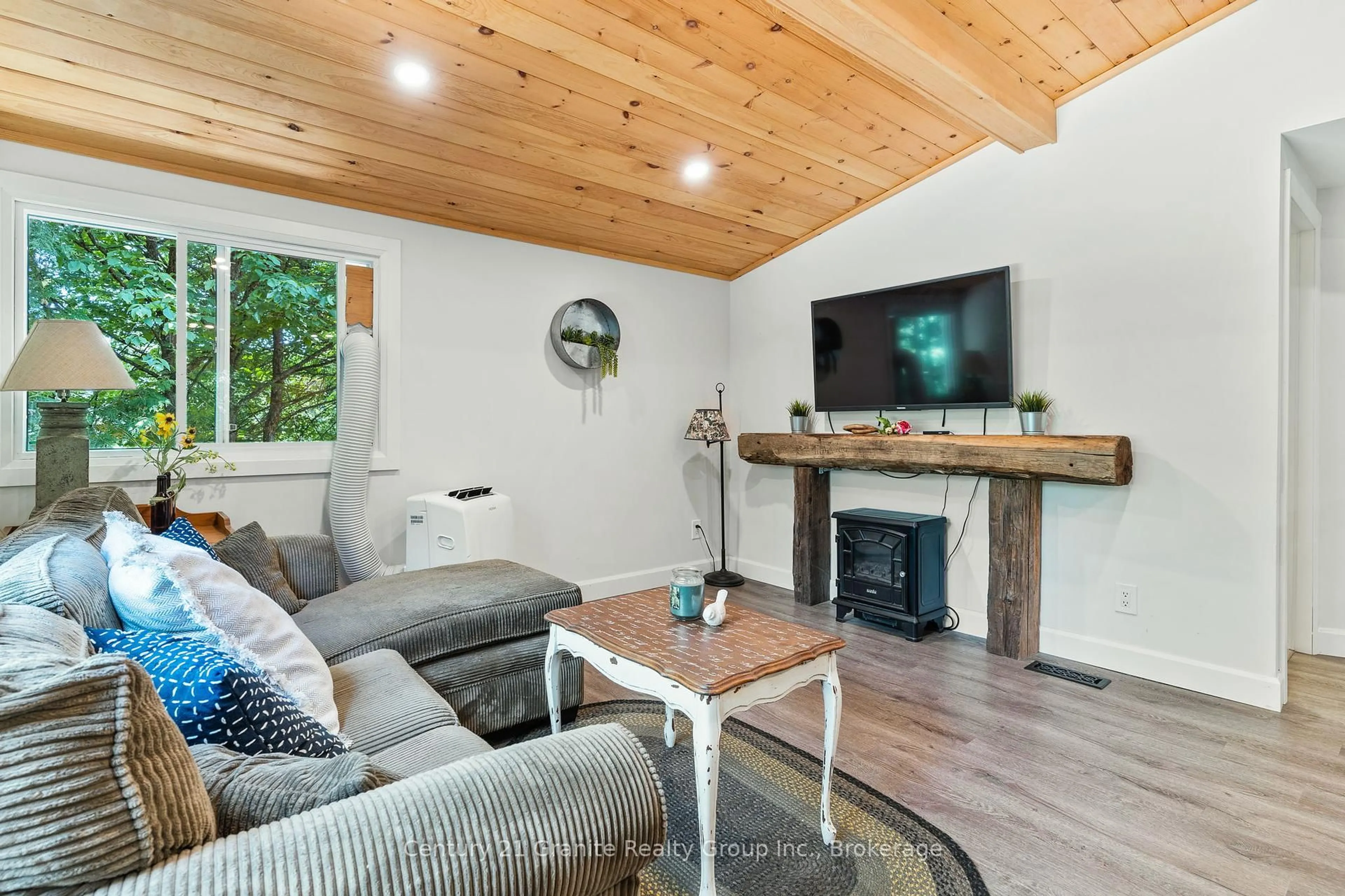 Living room with furniture, wood/laminate floor for 10979 Highway 118, Algonquin Highlands Ontario K0M 1S0
