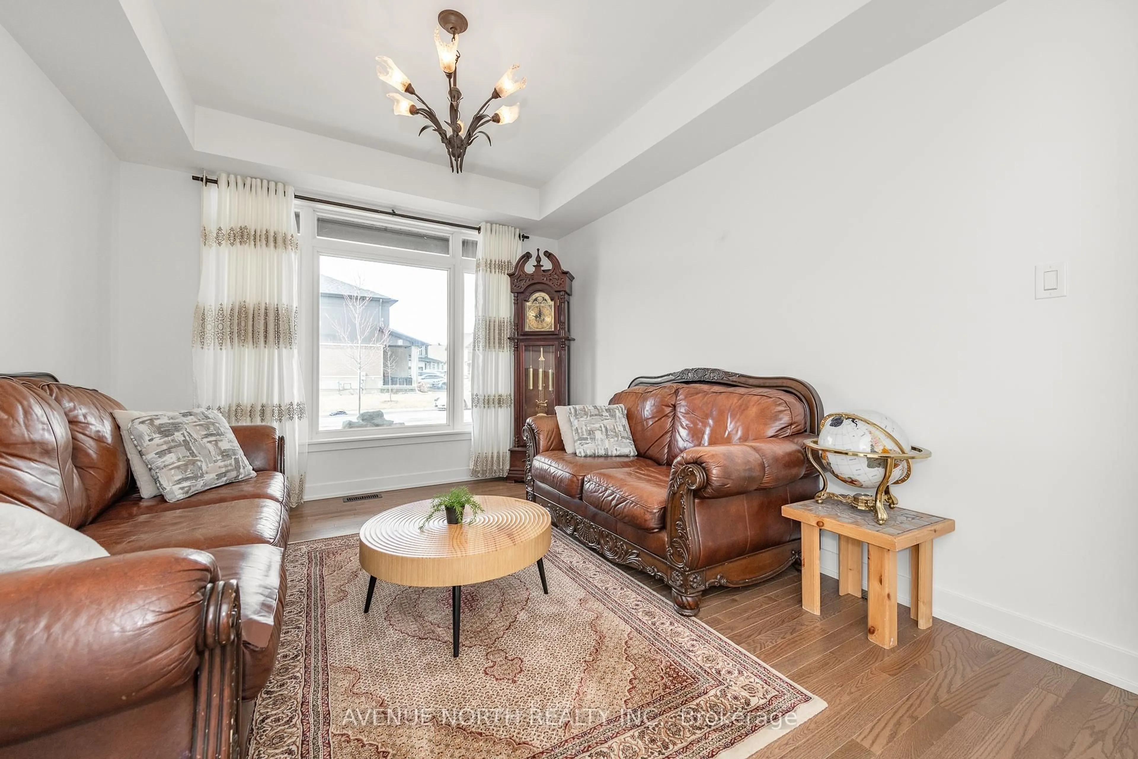 Living room with furniture, wood/laminate floor for 219 Reisling Way, Ottawa Ontario K1T 0X1