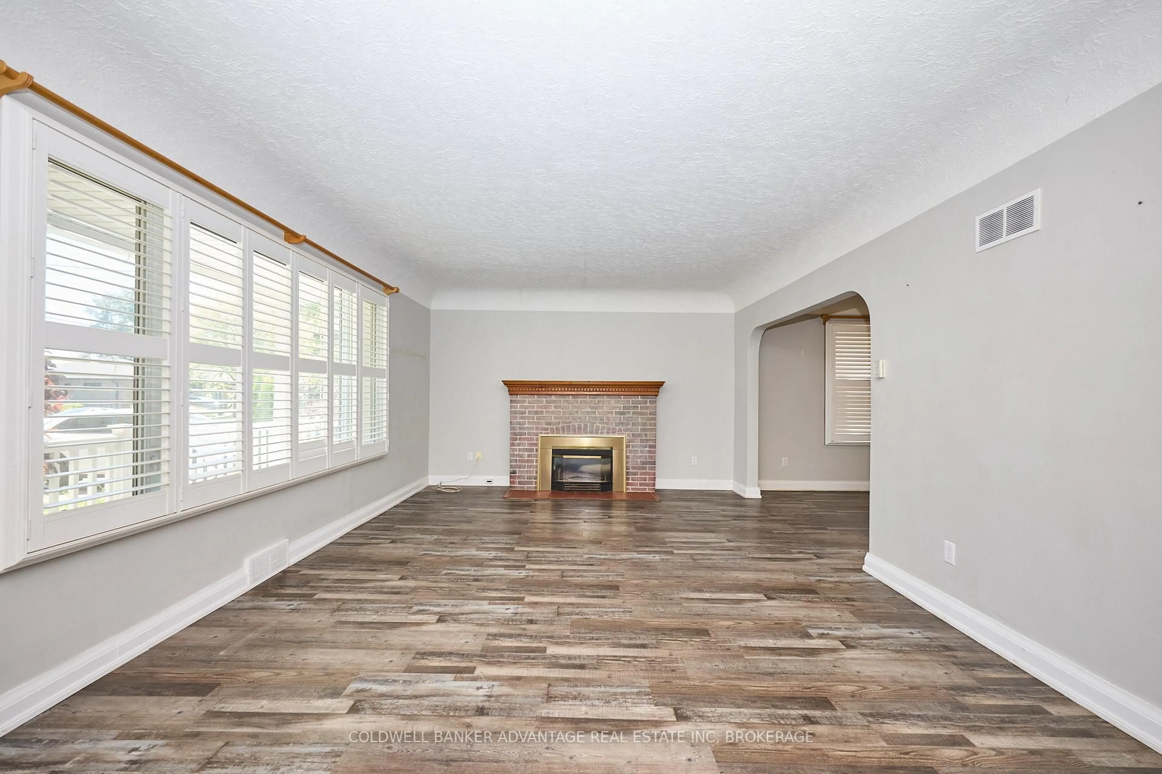 Living room with furniture, wood/laminate floor for 49 Carlton Ave, Welland Ontario L3C 1P8