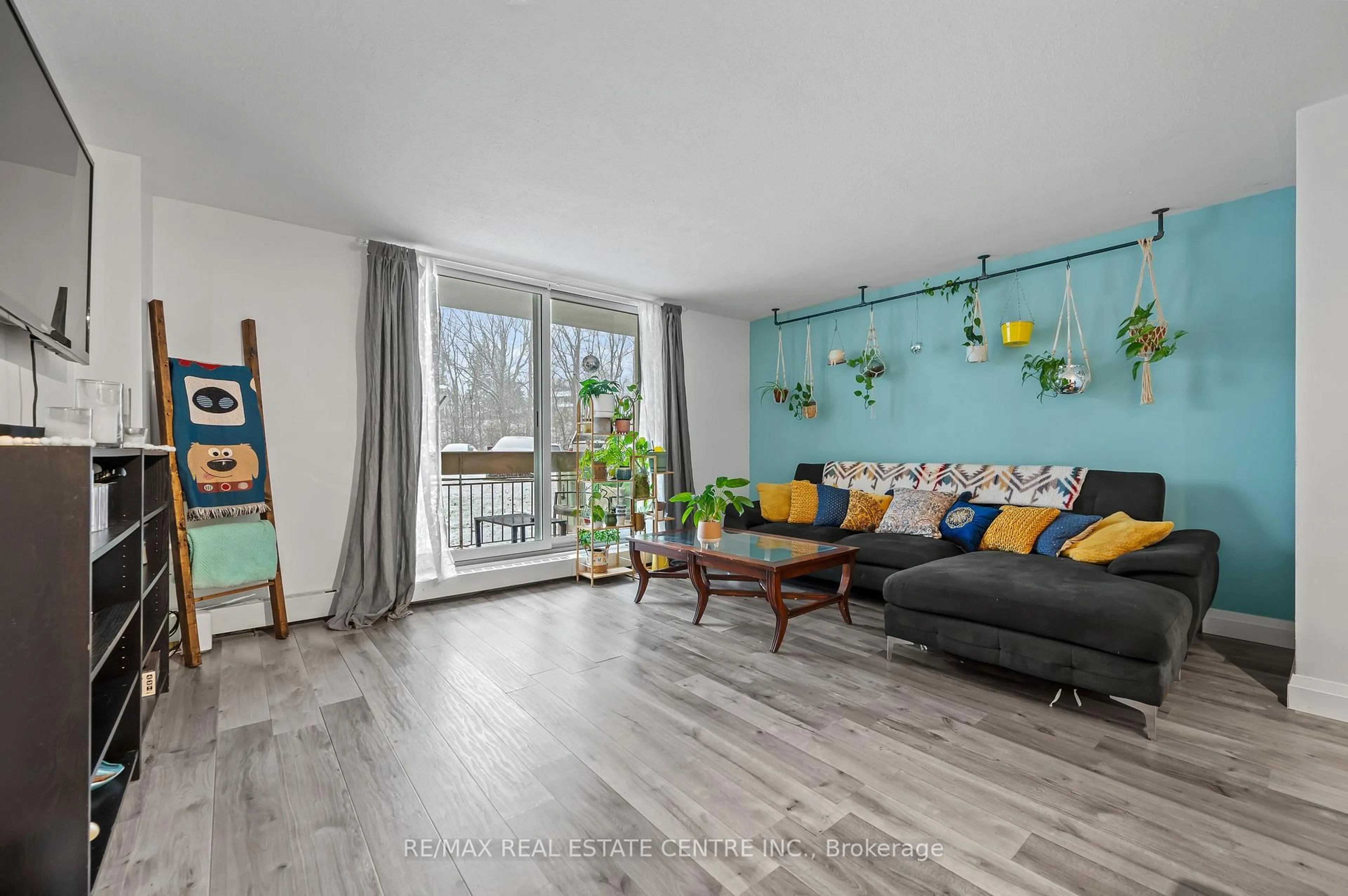Living room with furniture, wood/laminate floor for 350 Quigley Rd #141, Hamilton Ontario L8K 5N2