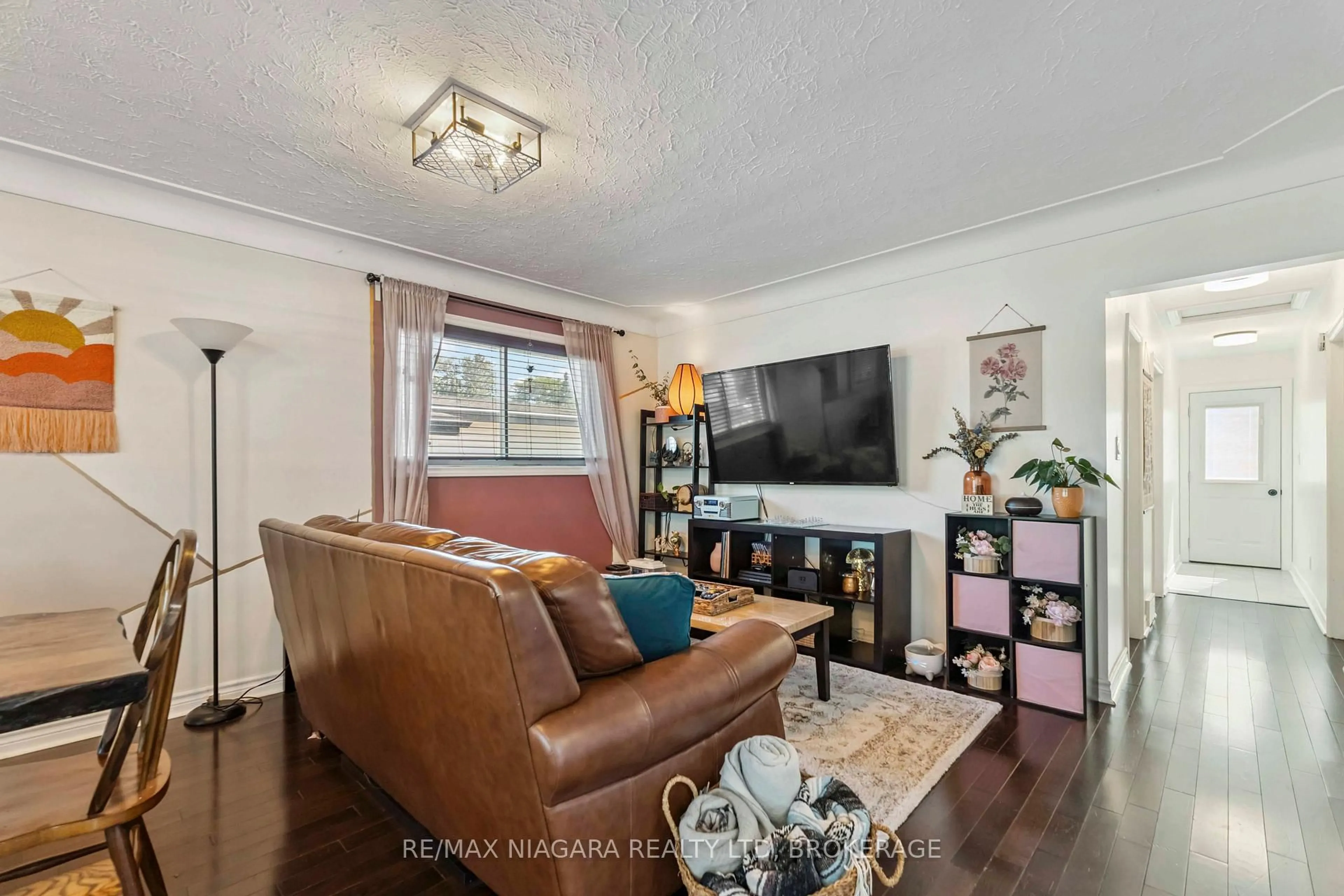 Living room with furniture, wood/laminate floor for 7452 Dorchester Rd, Niagara Falls Ontario L2G 5W1