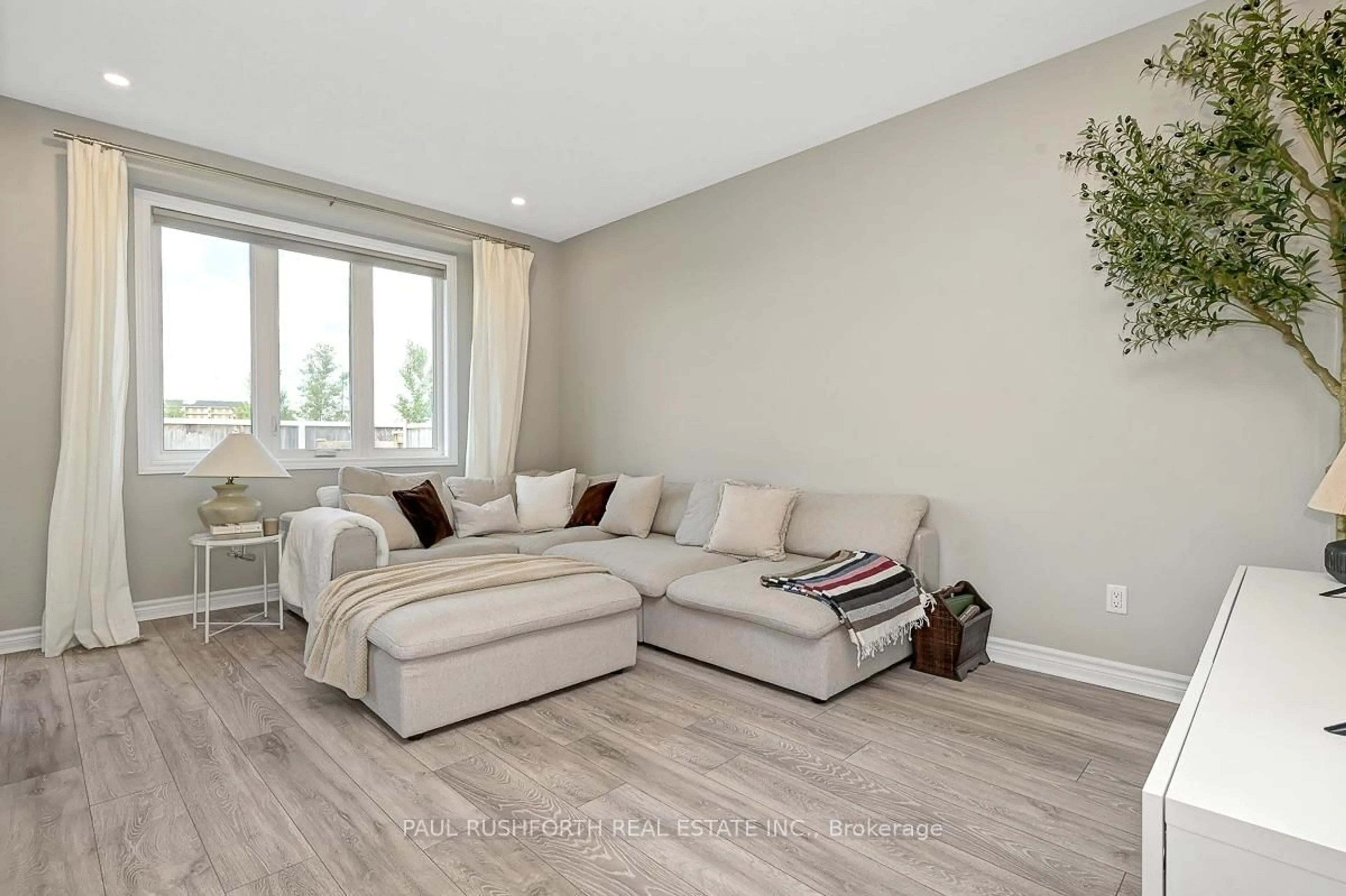 Living room with furniture, wood/laminate floor for 104 Livorno Crt, Ottawa Ontario K4A 1J1