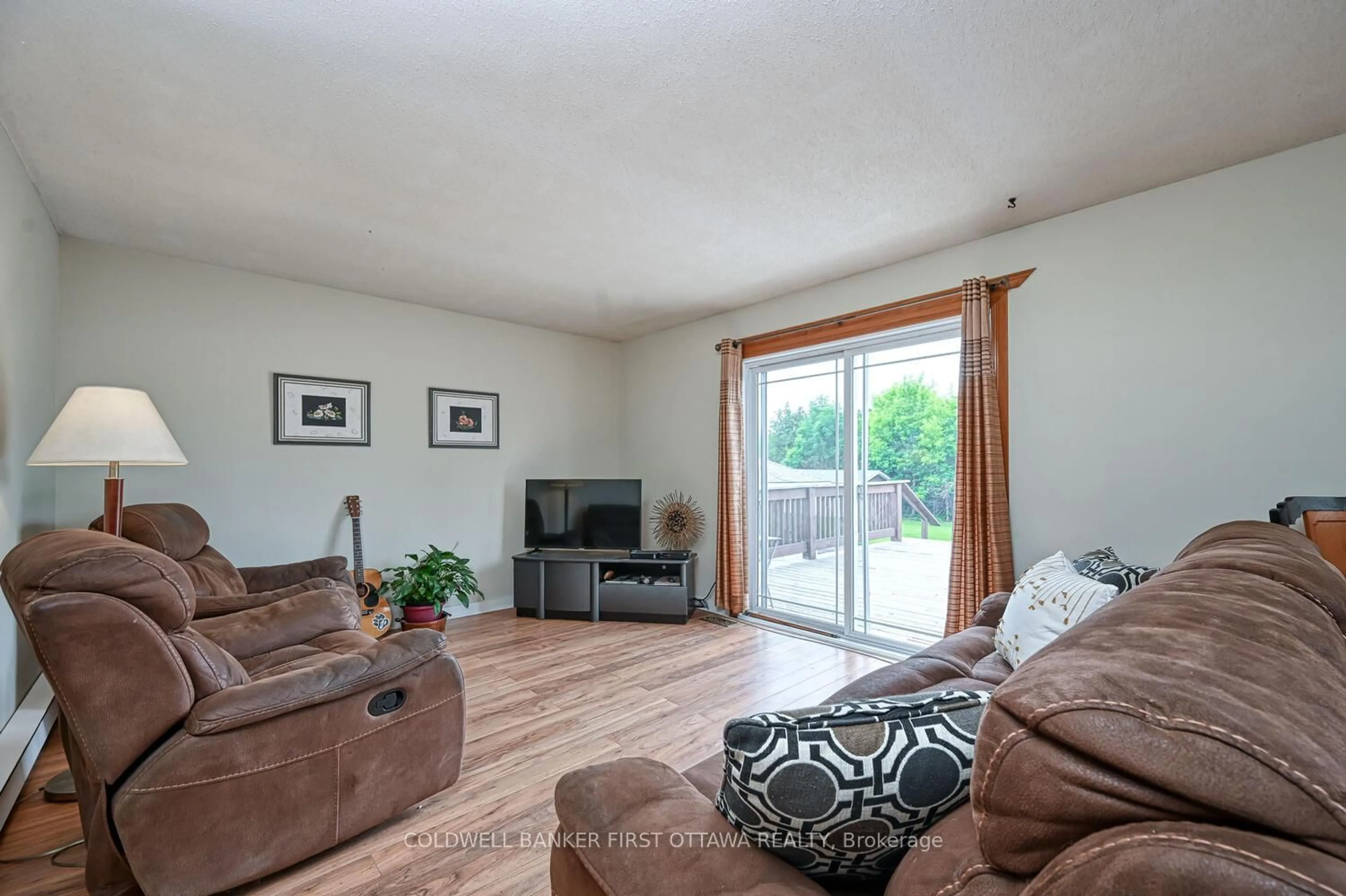 Living room with furniture, wood/laminate floor for 22 Poole Creek Cres, Stittsville Ontario K2S 1G4