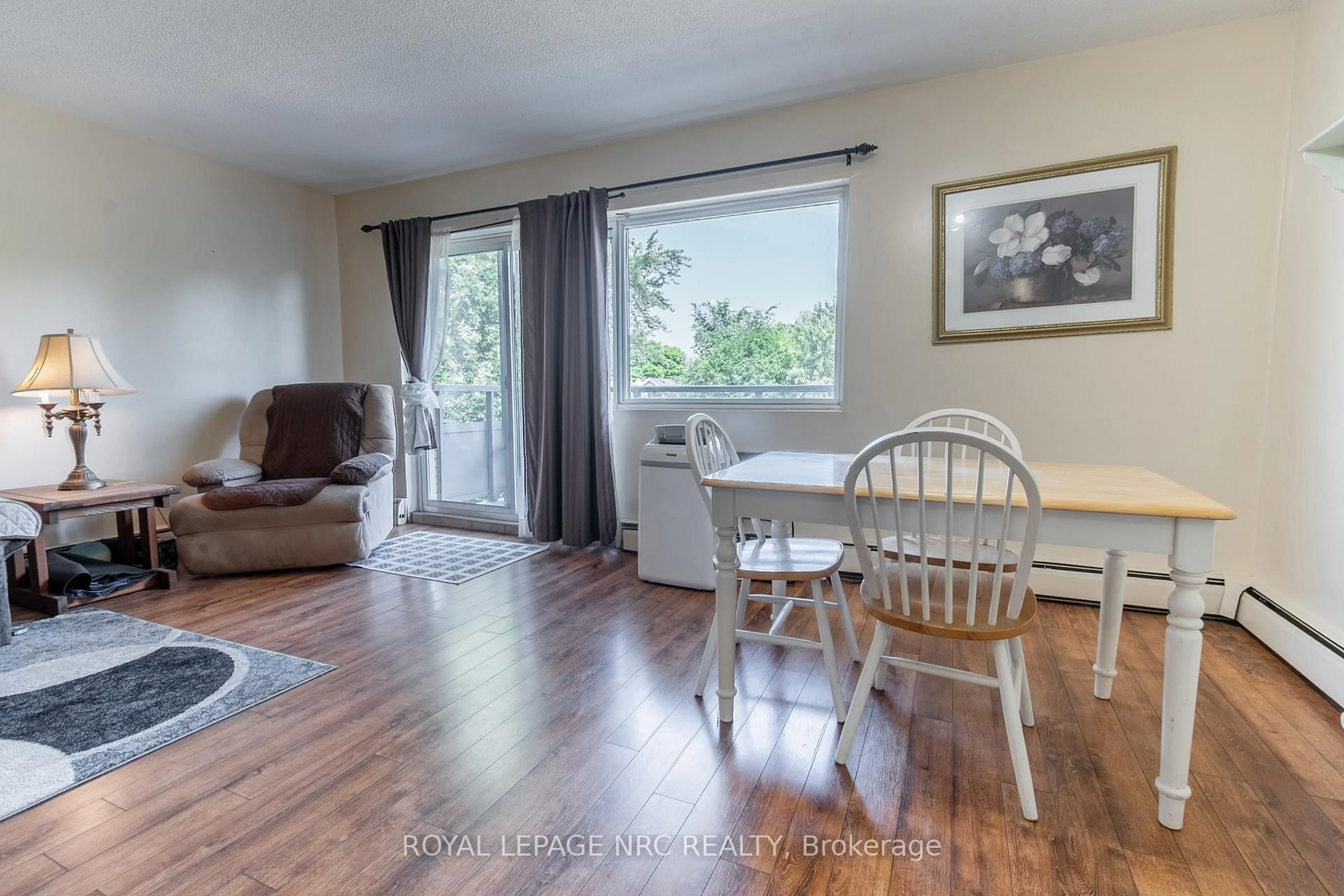 Living room with furniture, wood/laminate floor for 242 Oakdale Ave #316, St. Catharines Ontario L2P 3K5