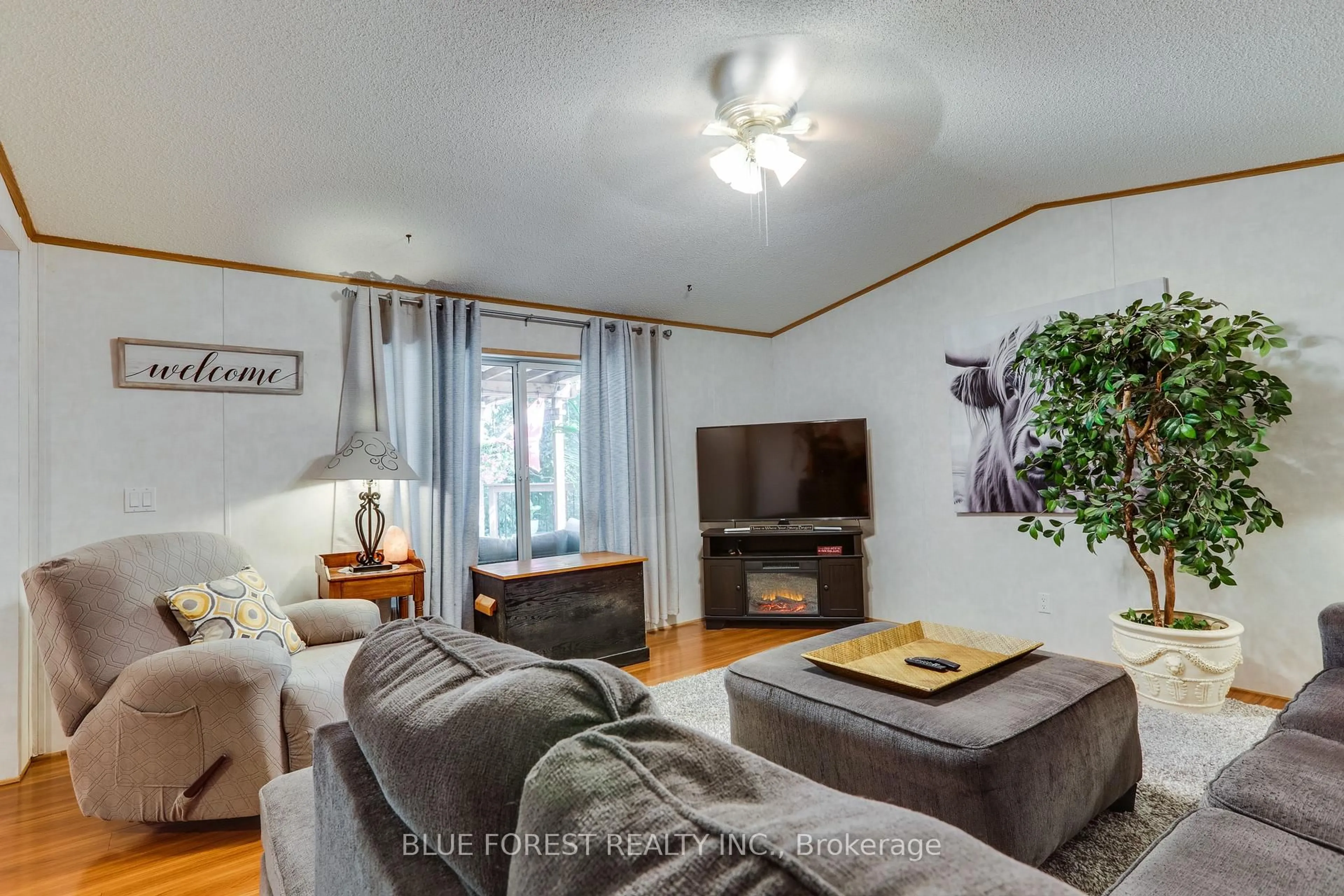 Living room with furniture, wood/laminate floor for 3100 Dorchester Rd #52, Thames Centre Ontario N0L 1G5