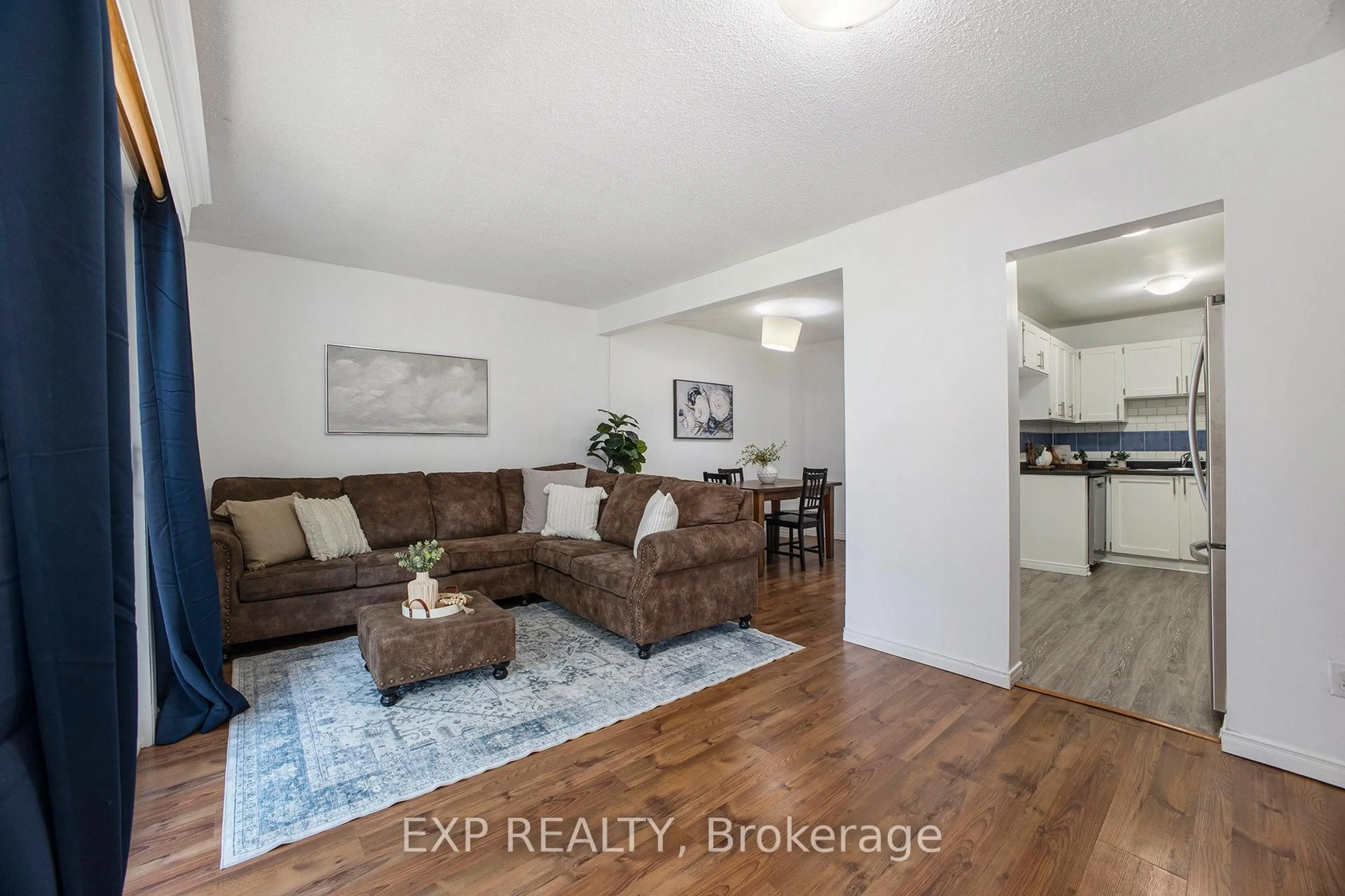Living room with furniture, wood/laminate floor for 30 Baneberry Cres #68, Ottawa Ontario K2L 2Y4