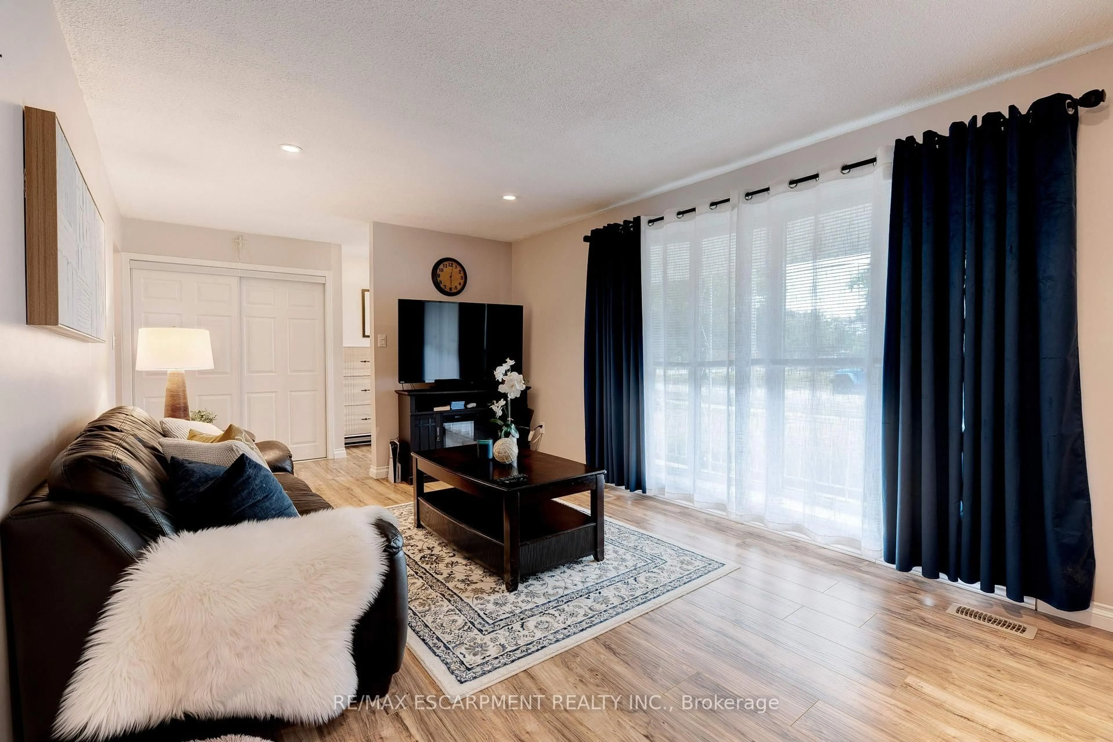 Living room with furniture, wood/laminate floor for 26 Madoc St, Hamilton Ontario L8E 3S7